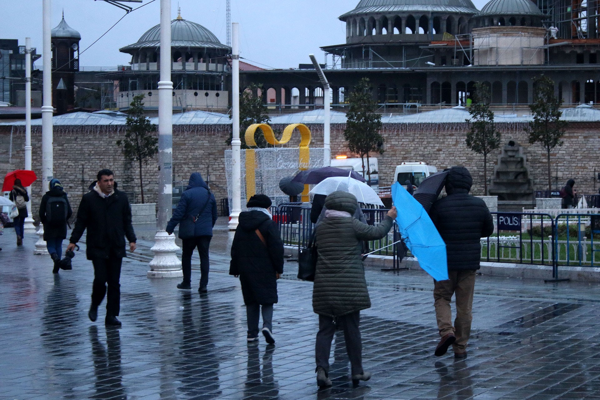 Taksim'de fırtına nedeniyle zorluk yaşayan insanlar