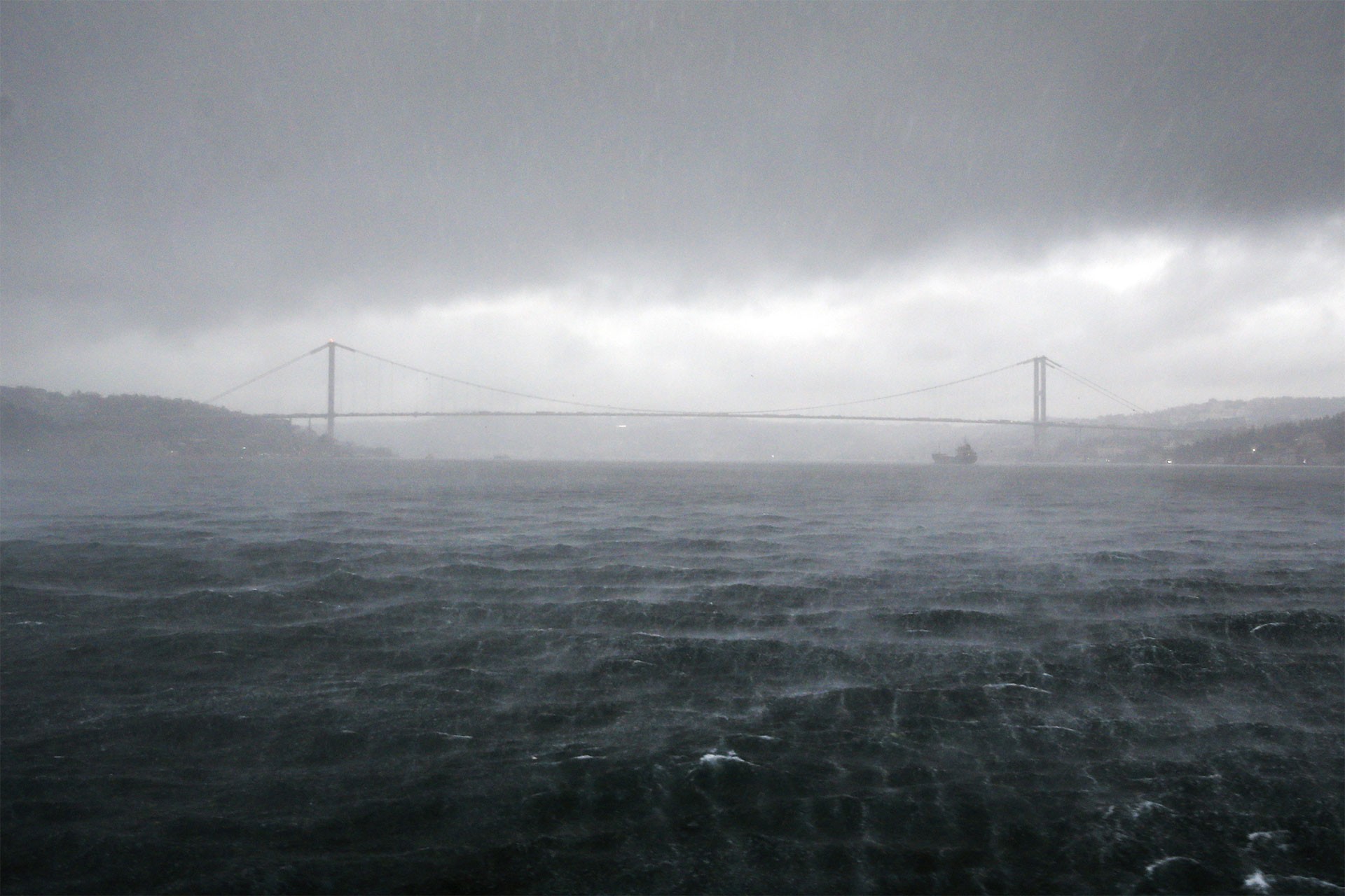 İstanbul'da sağanak yağış ve sisli bir görünümle boğaz köprüsü.