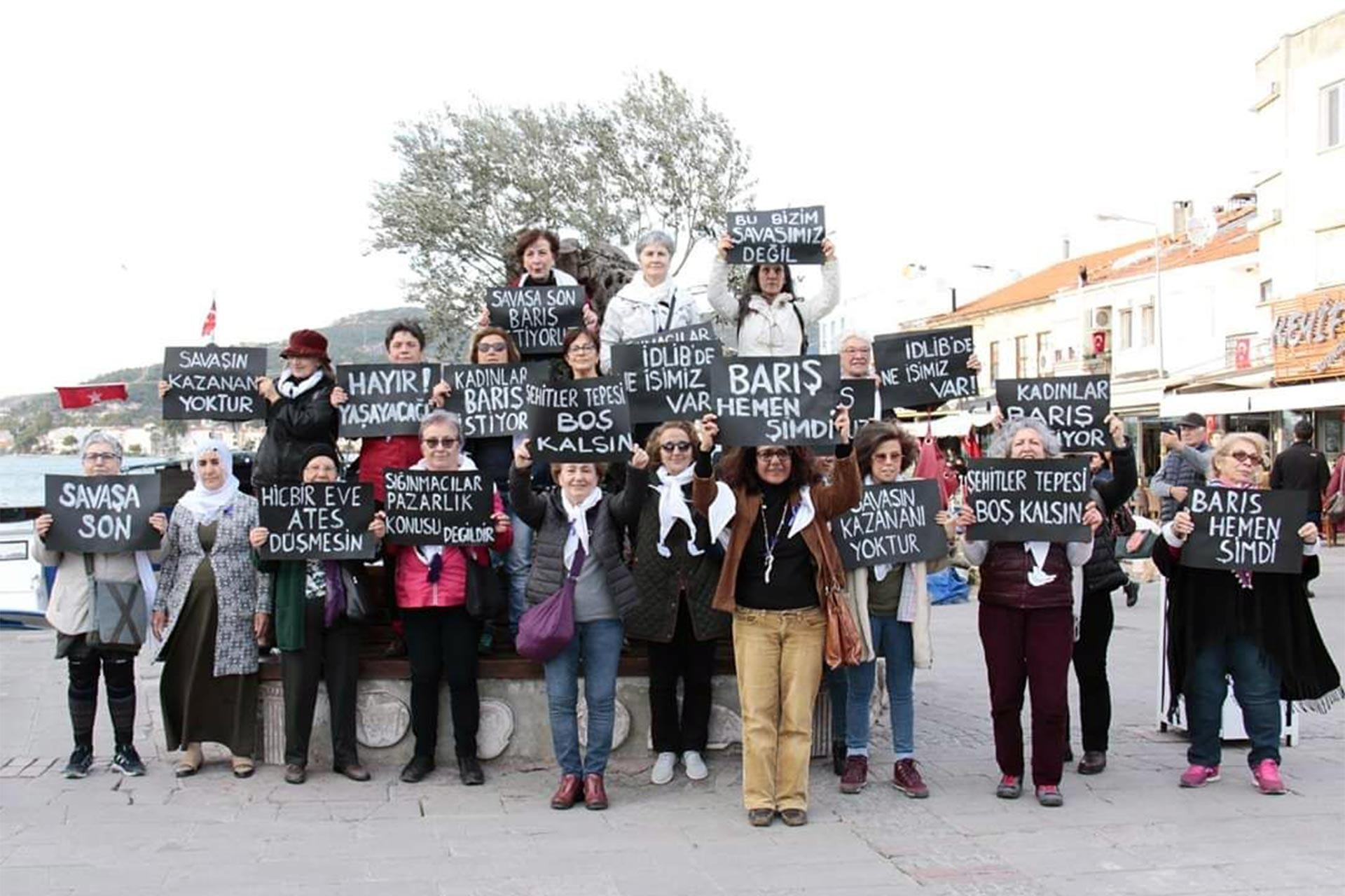 Foça'da barış çağrısı için eylem yapan kadınlar döviz taşıyor