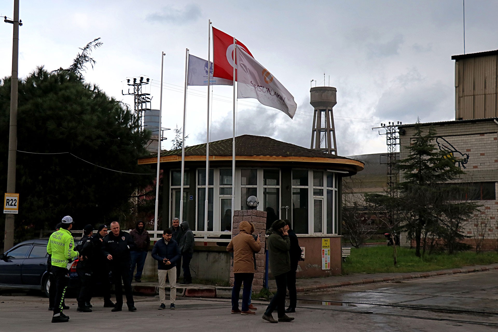 Fabrikanın giriş kapısı, polis ve işçiler