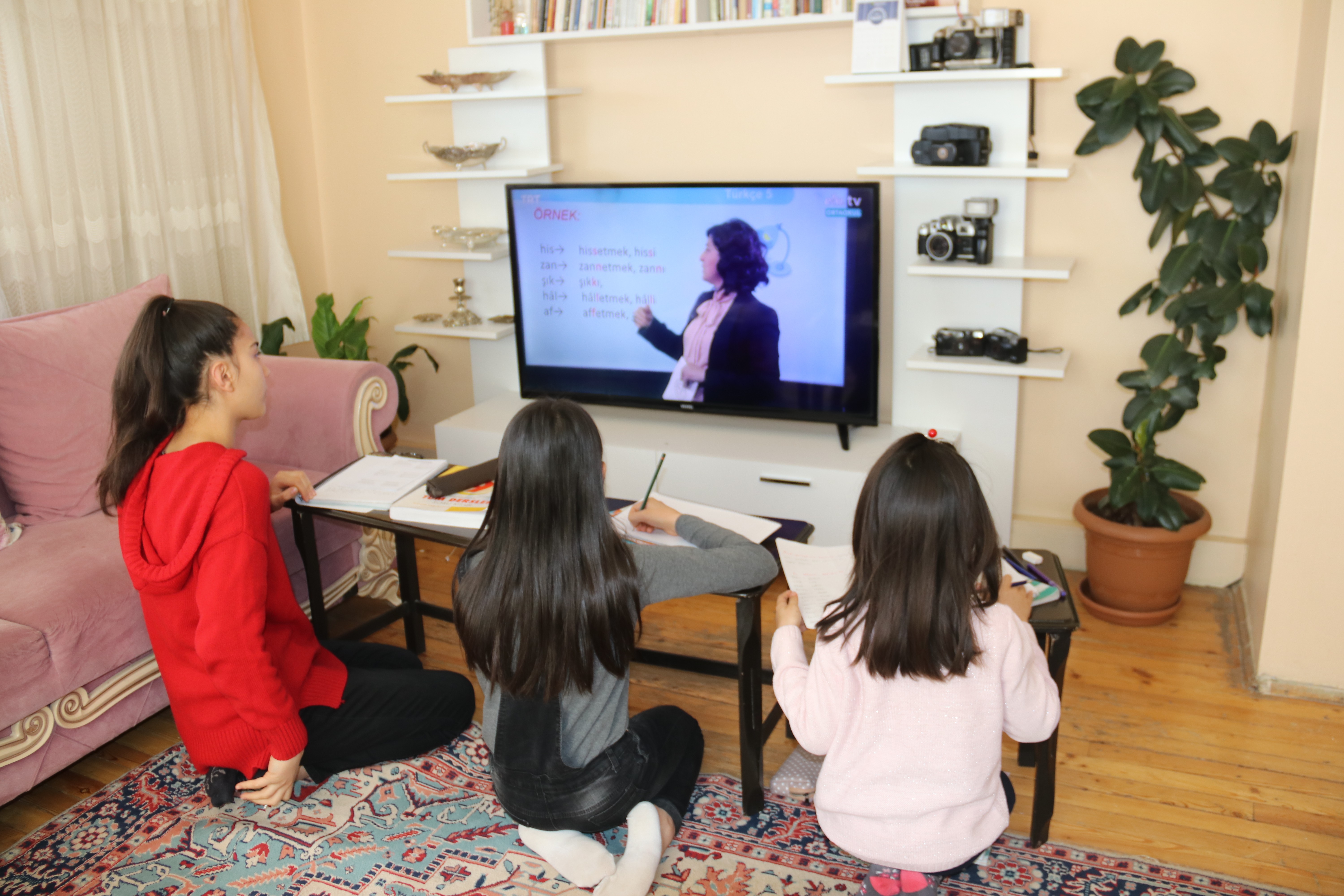 televizyonun önünde oturan üç çocuk