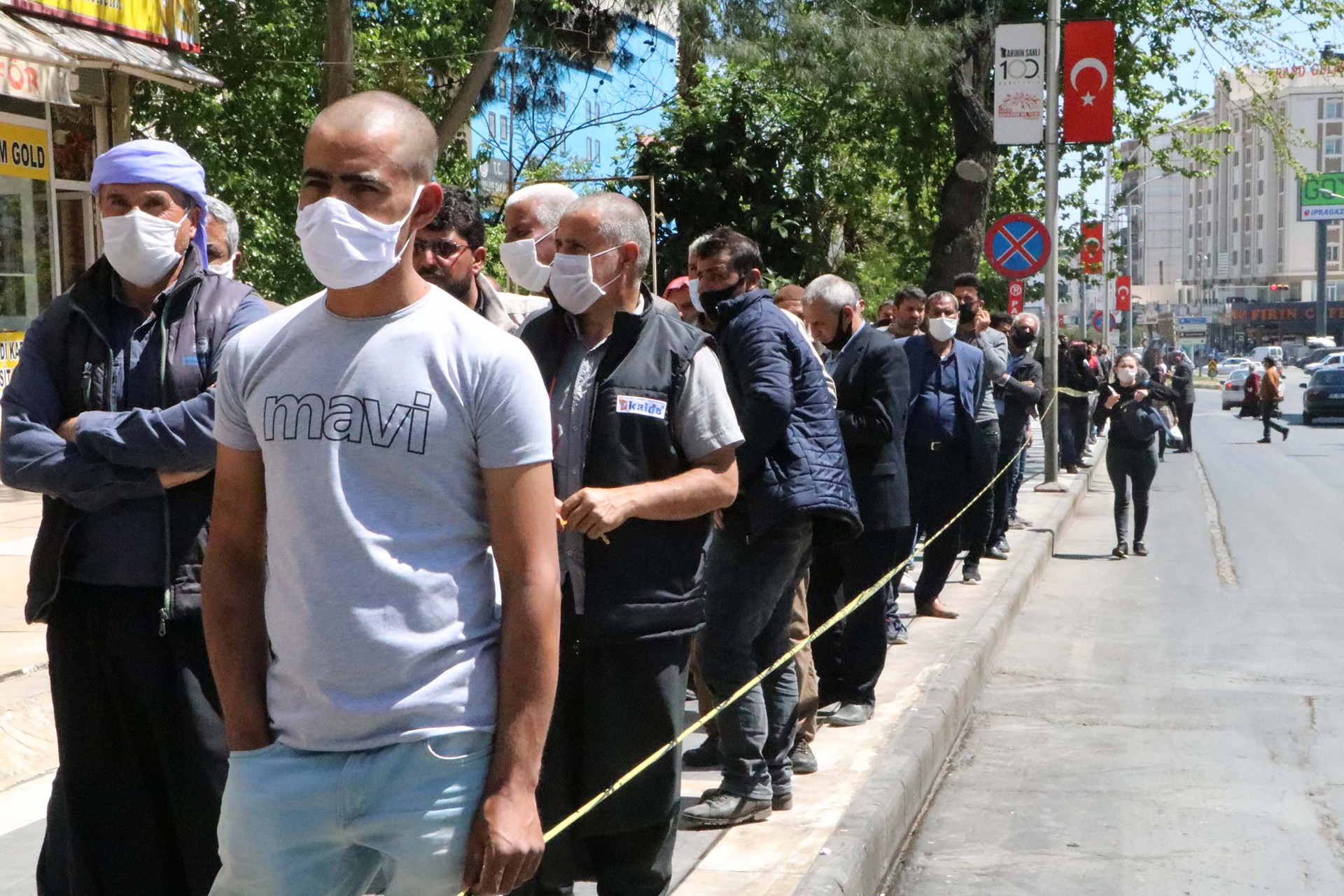 Uzun kuyrukta dip dibe bekleten mevsimlik tarım işçileri