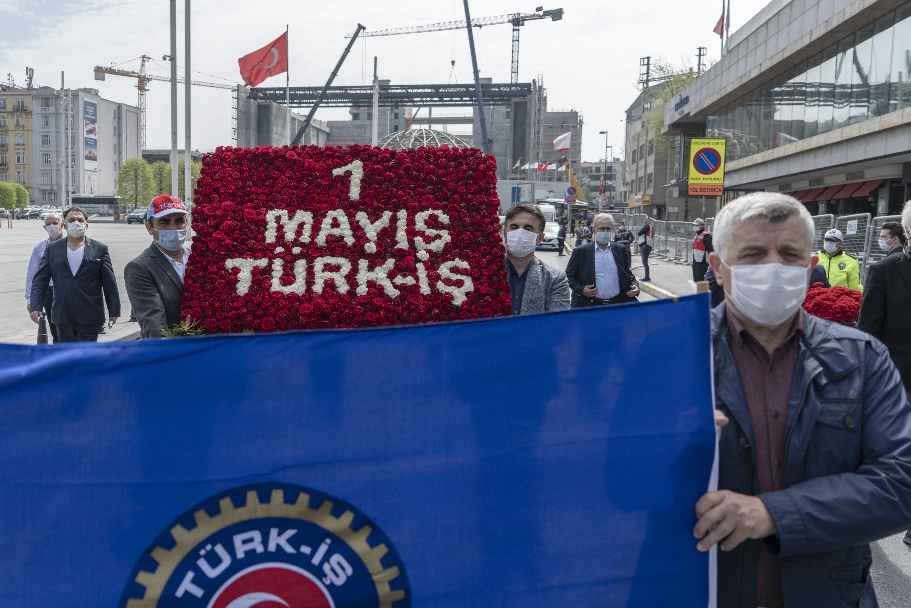 türk-iş'in 1 mayıs çelengi ve taşıyan iki kişi