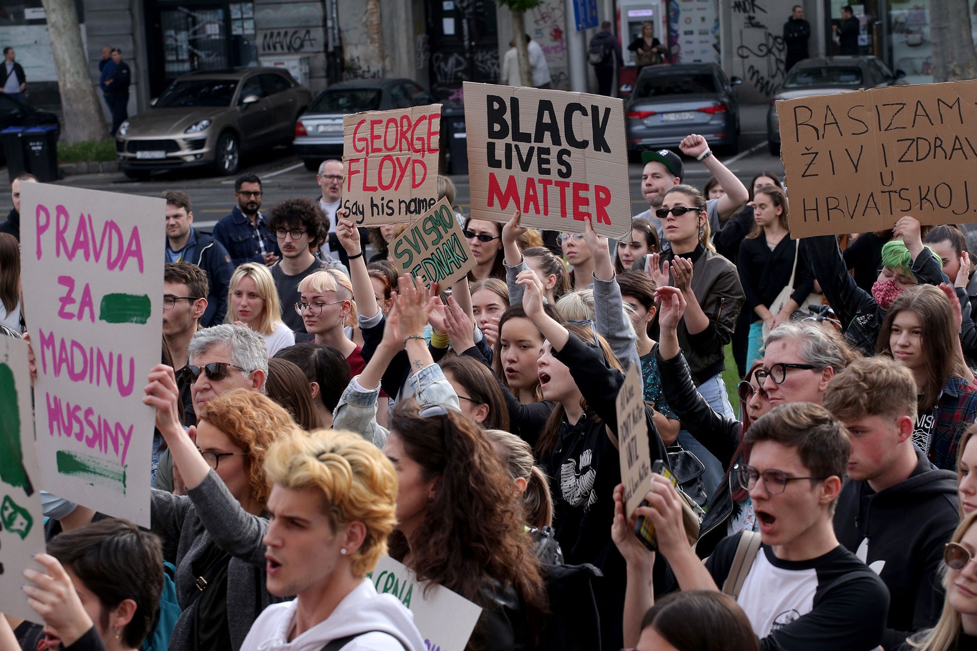 Irkçılık karşıtı ve Black Lives Matter yazılı dövizler taşıyan gençler