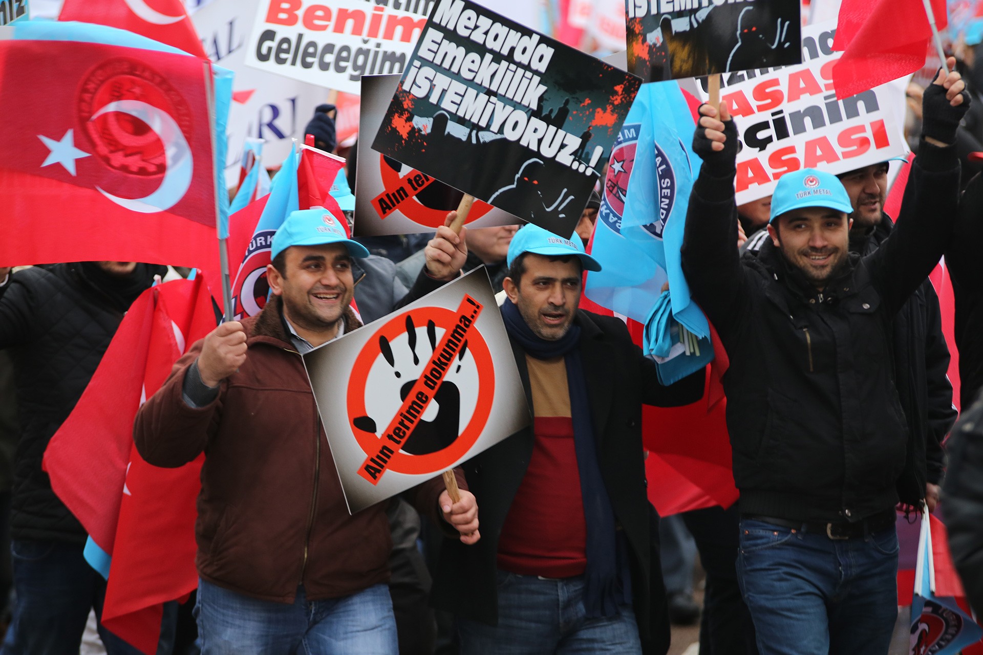 İşçi eyleminde kıdem tazminatına ve mezarda emekliliğe ilişkin dövizler taşıyan işçiler.