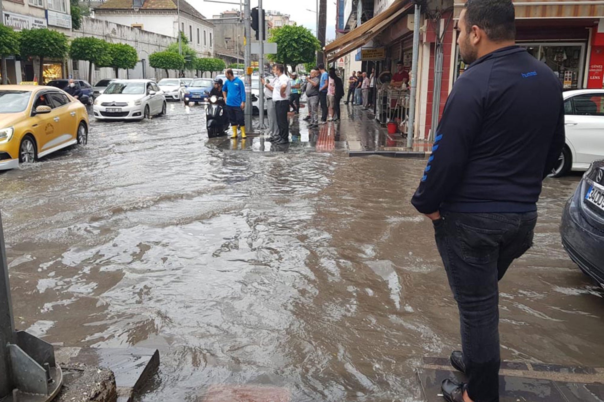 İskenderun'da su göle dönen yol, yola bakan bir genç (sağda)