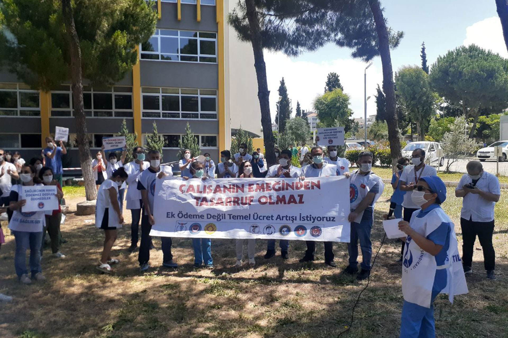 DEÜ Hastanesi sağlık çalışanları hastane bahçesinde hakları için basın açıklaması yaparken. 