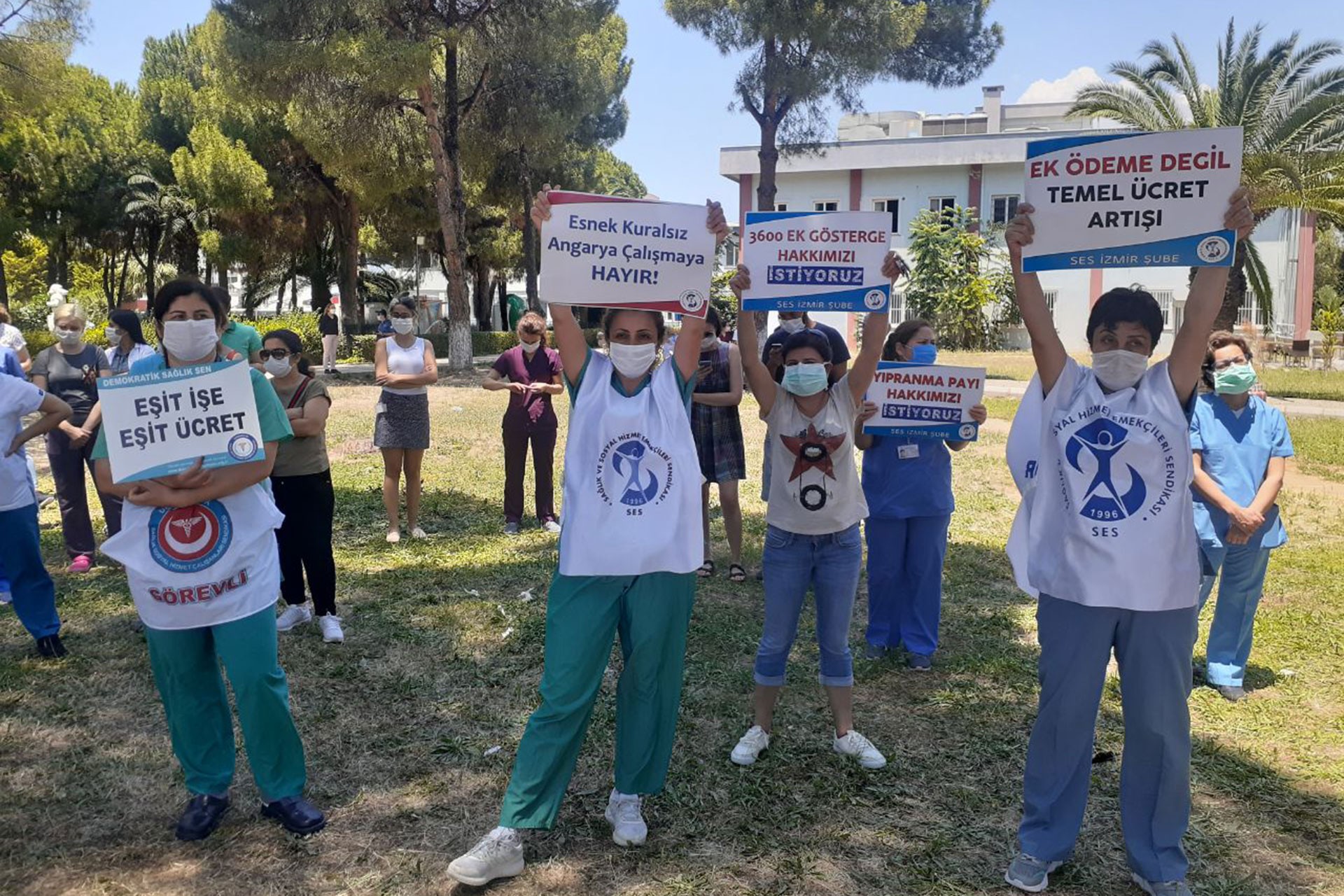 DEÜ Hastanesi sağlık çalışanları hastane bahçesinde hakları için basın açıklaması yaparken.