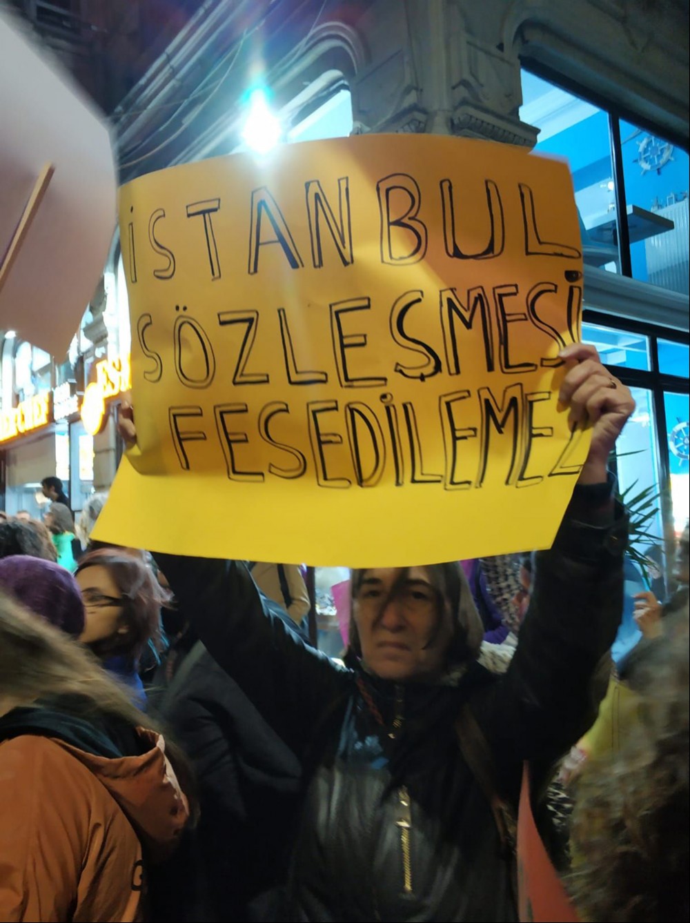 Elinde 'İstanbul Sözleşmesi feshedilemez' yazılı döviz tutan kadın.