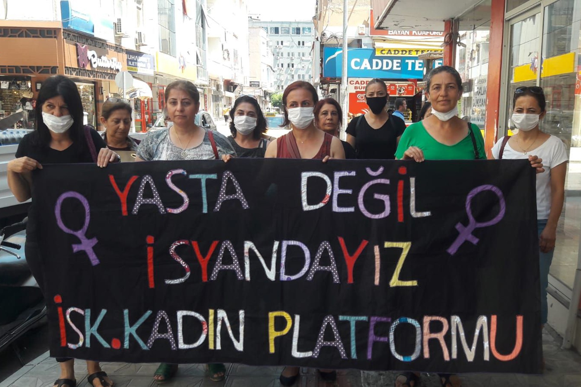 İskenderun Kadın Platformu'nun pankartı ve arkasında kadınlar