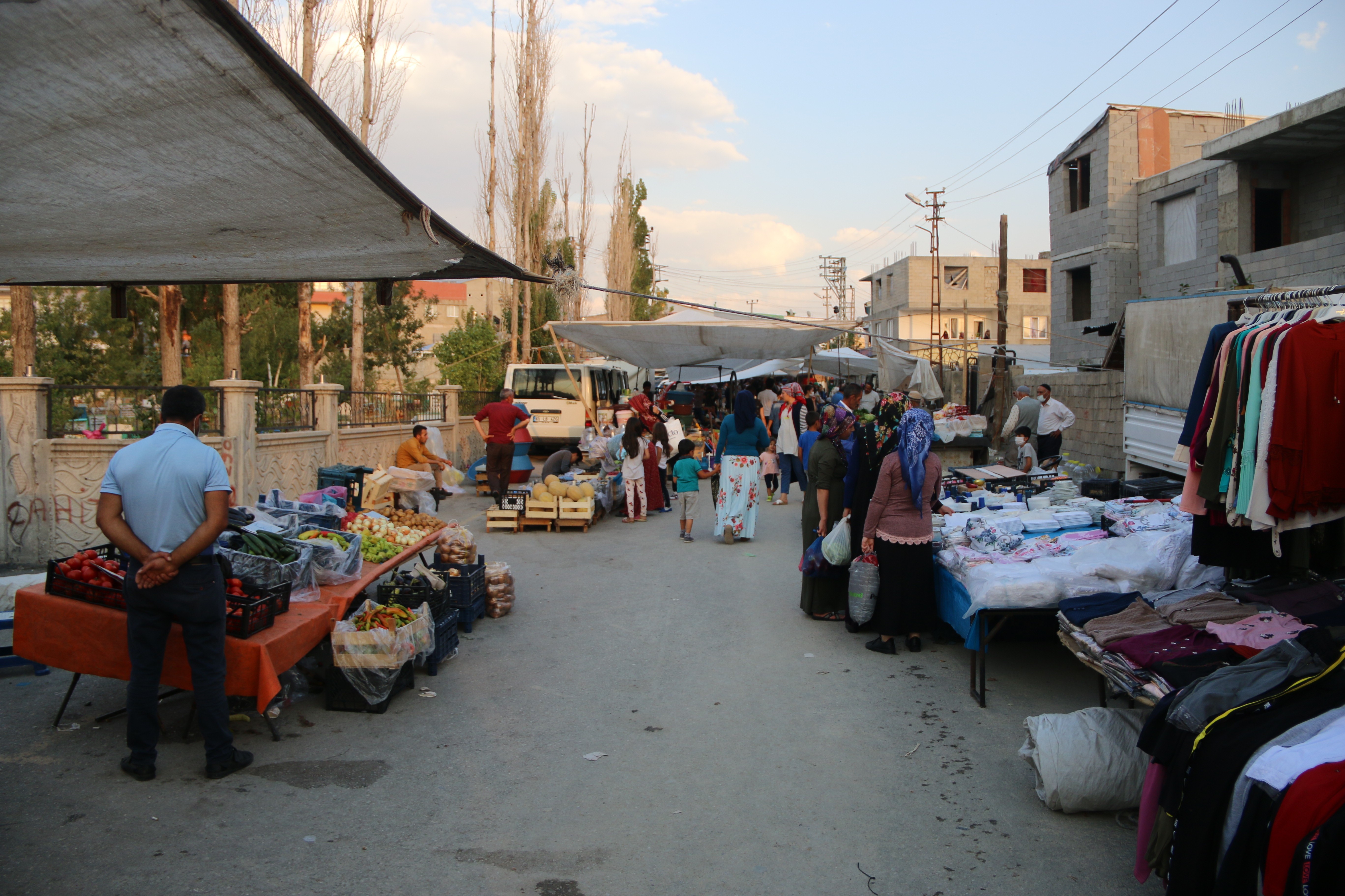 pazar tezgahları ve alışveriş yapan vatandaşlar