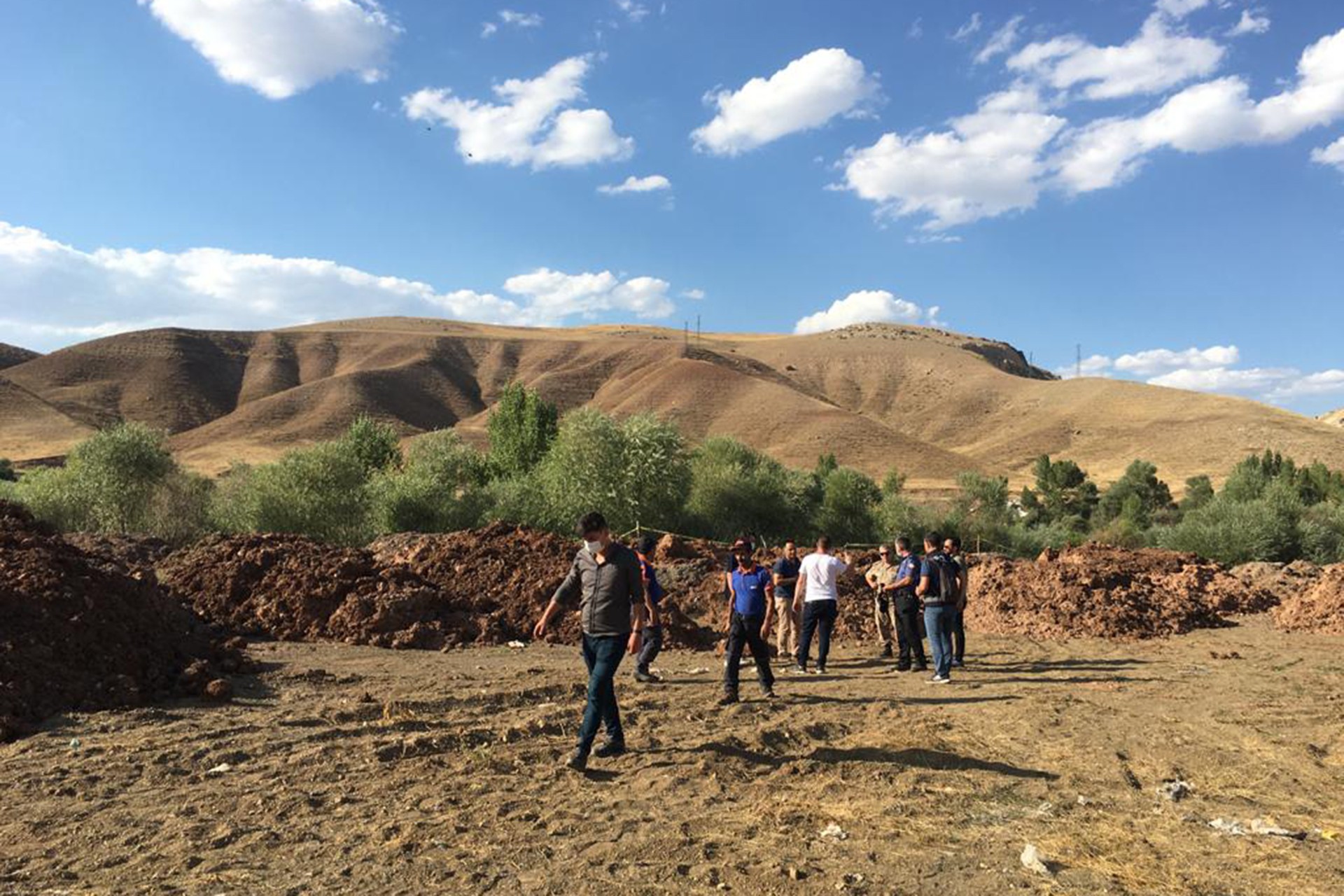 Erzincan'da toprağa gömülü olan erkek cesedinin bulunduğu alanda ekipler çalışma yaparken.