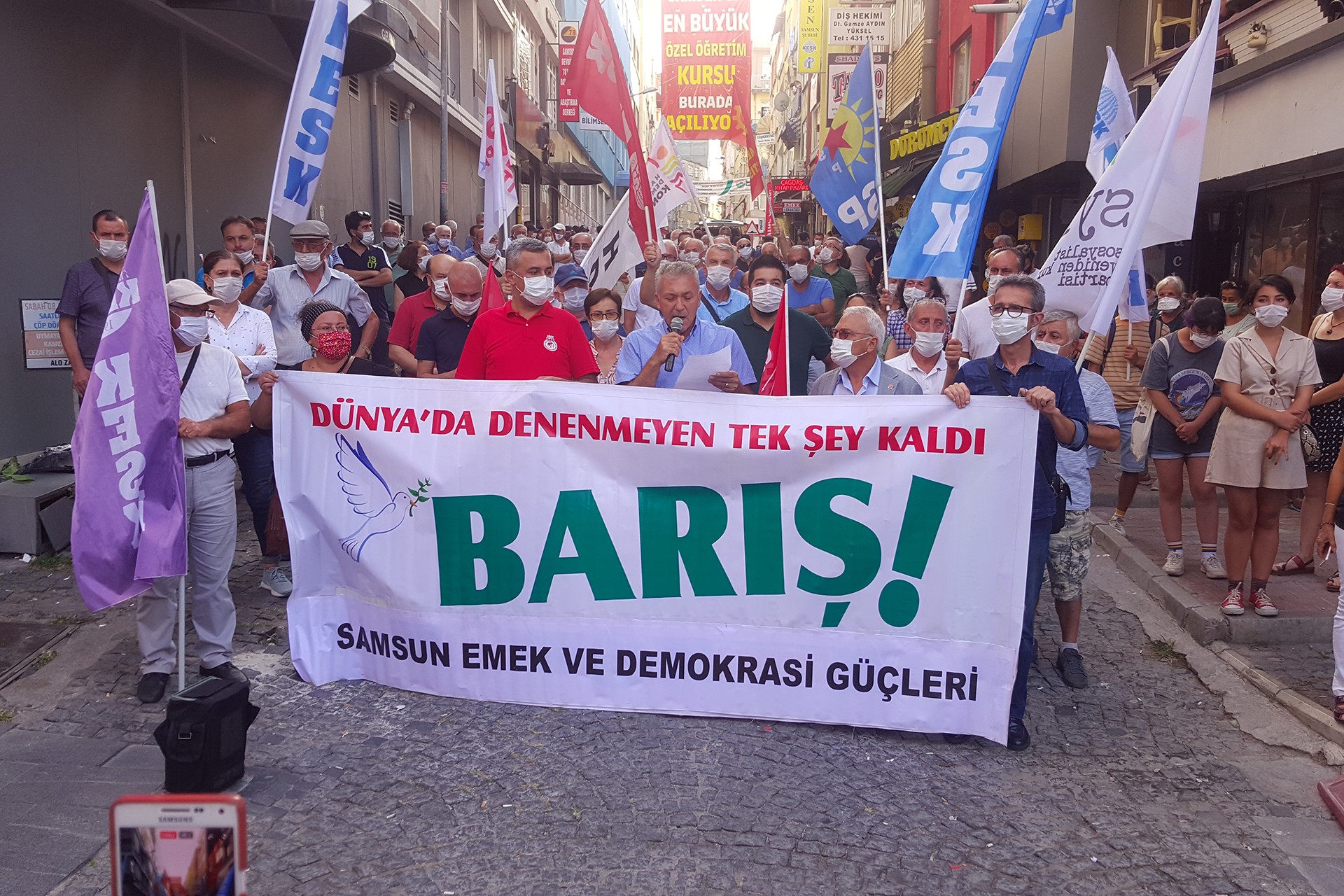 Samsun Emek ve Demokrasi Güçleri pankartı ve arkasında yüzü maskeli kitle