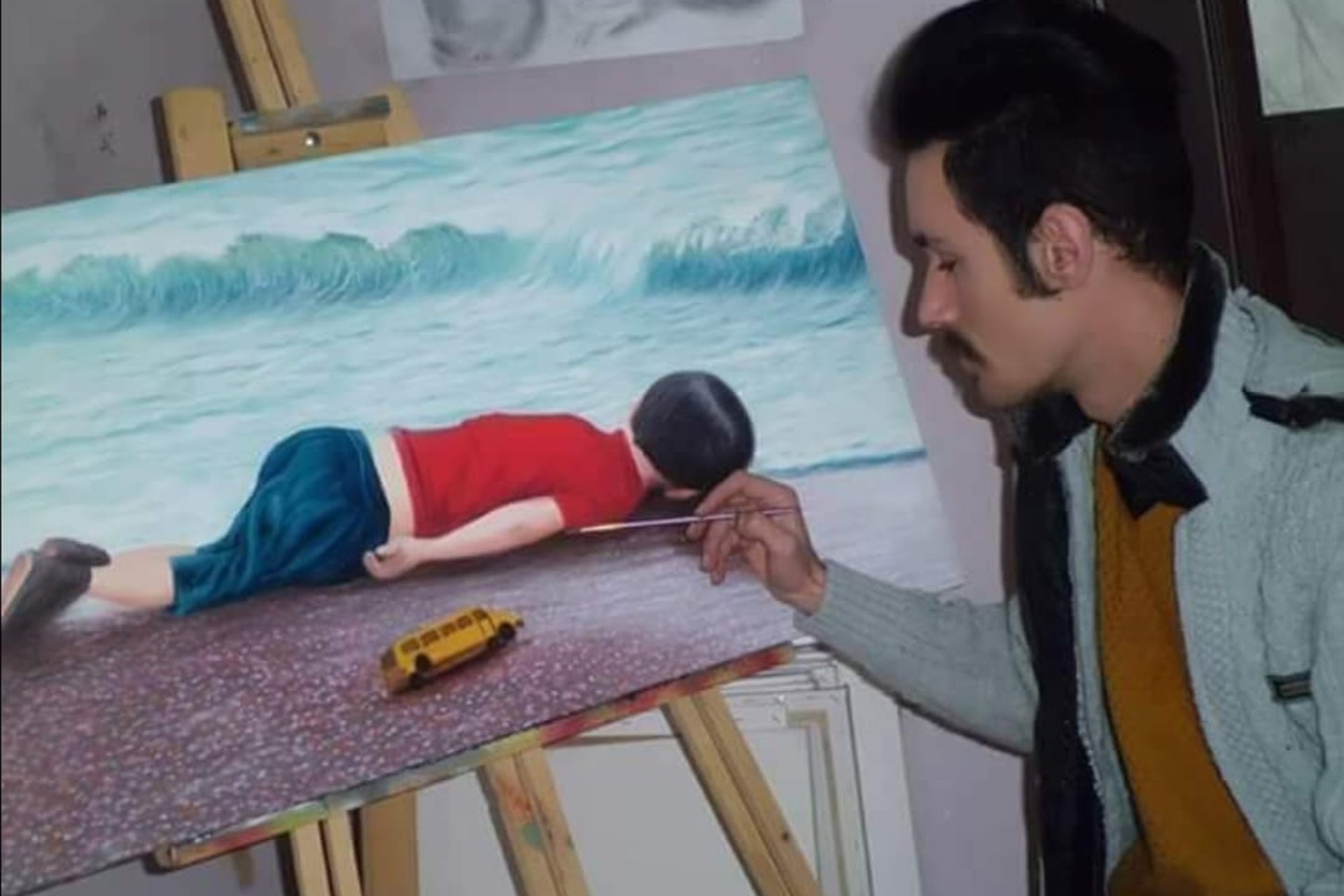 Ressam Kıvanç Bilir, denizde boğularak hayatını kaybeden mülteci çocuk Aylan Kurdi'yi resmettiği eserin başında iken.