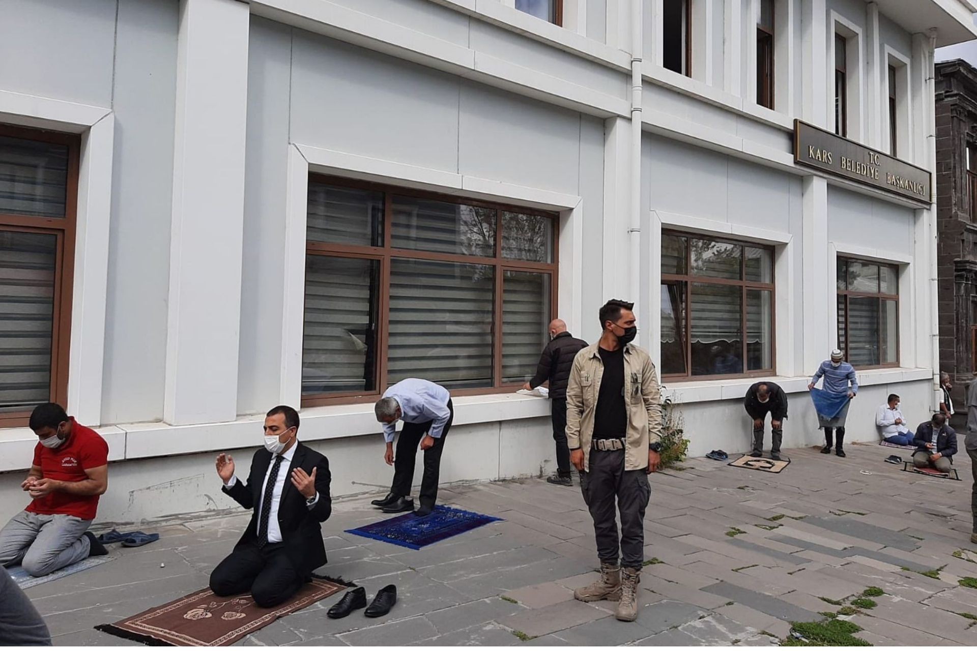 Kars Belediyesi önünde namaz kılan insanlar