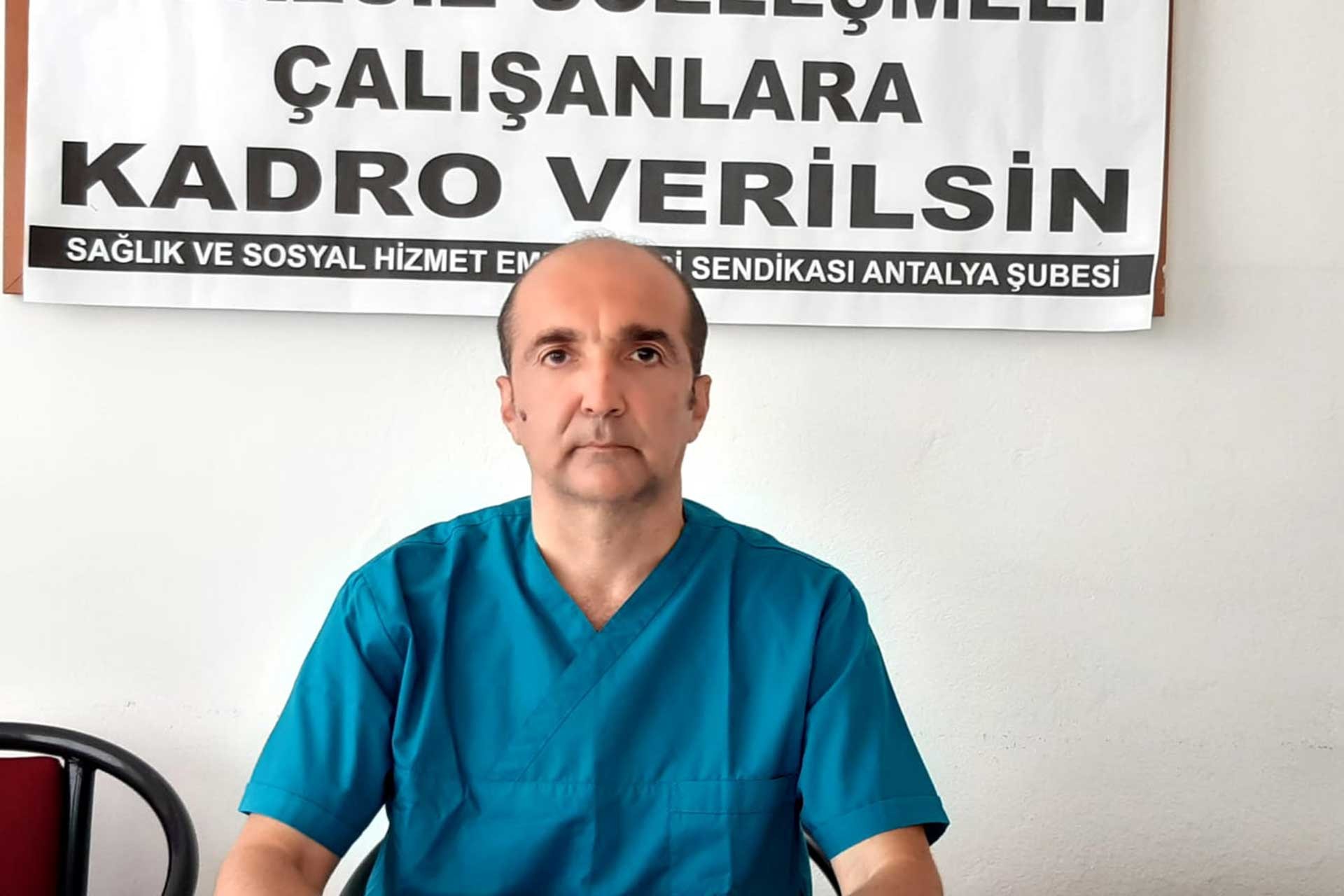 Dr. Kaan Taşer, arkasındaki duvarda SES pankartı