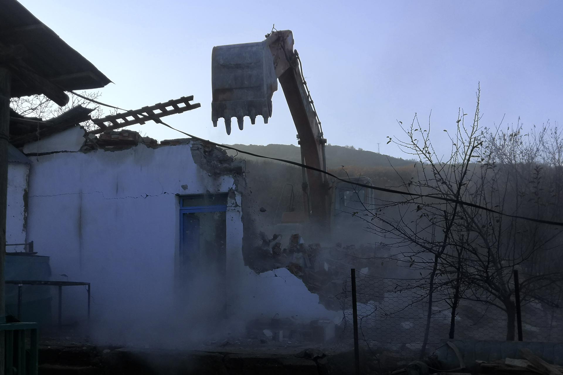 Dersim'de iş makinesi bir binayı yıkıyor