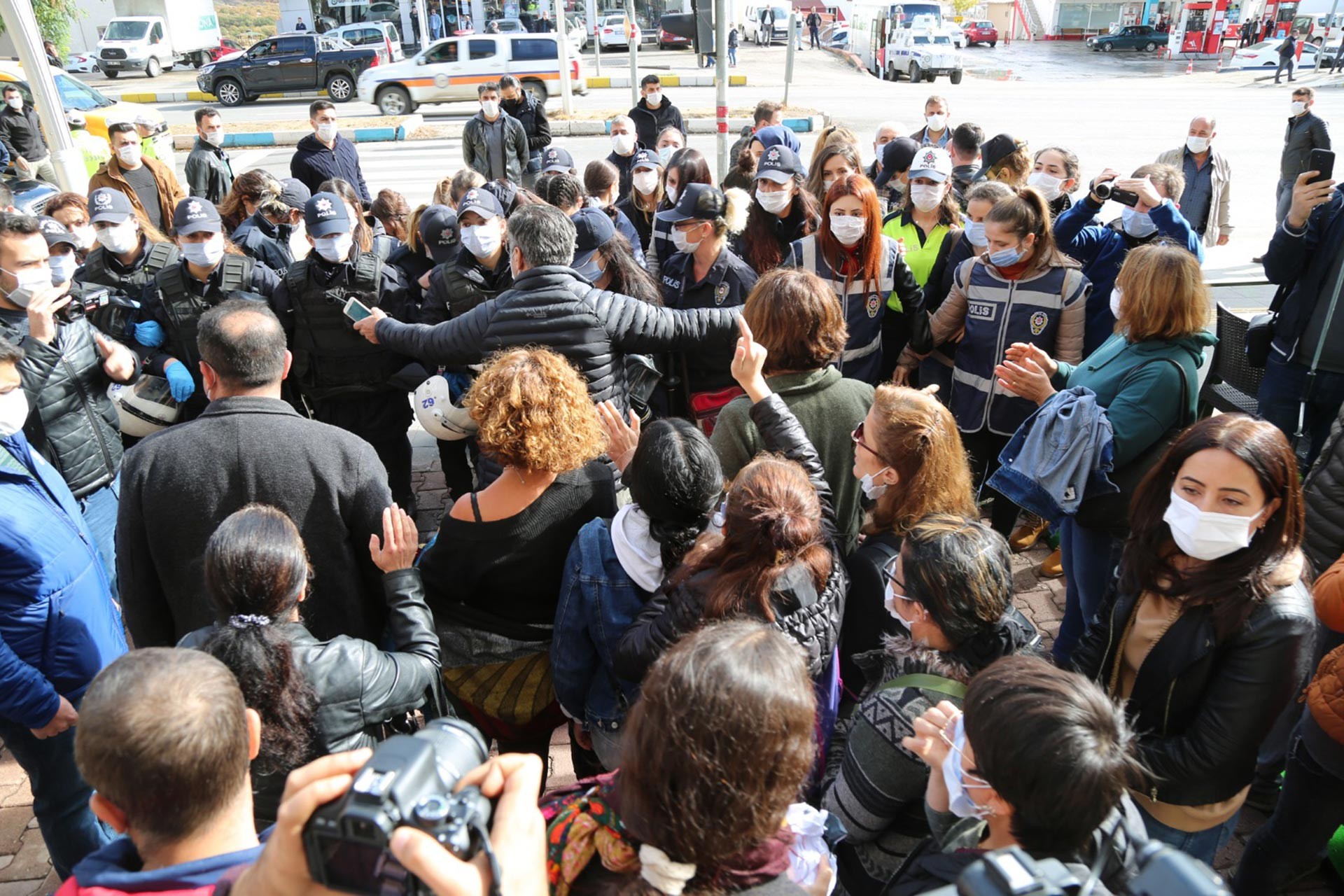 Taciz eyleminde kadınlar ve önlerinde onları engelleyen çok sayıda polis