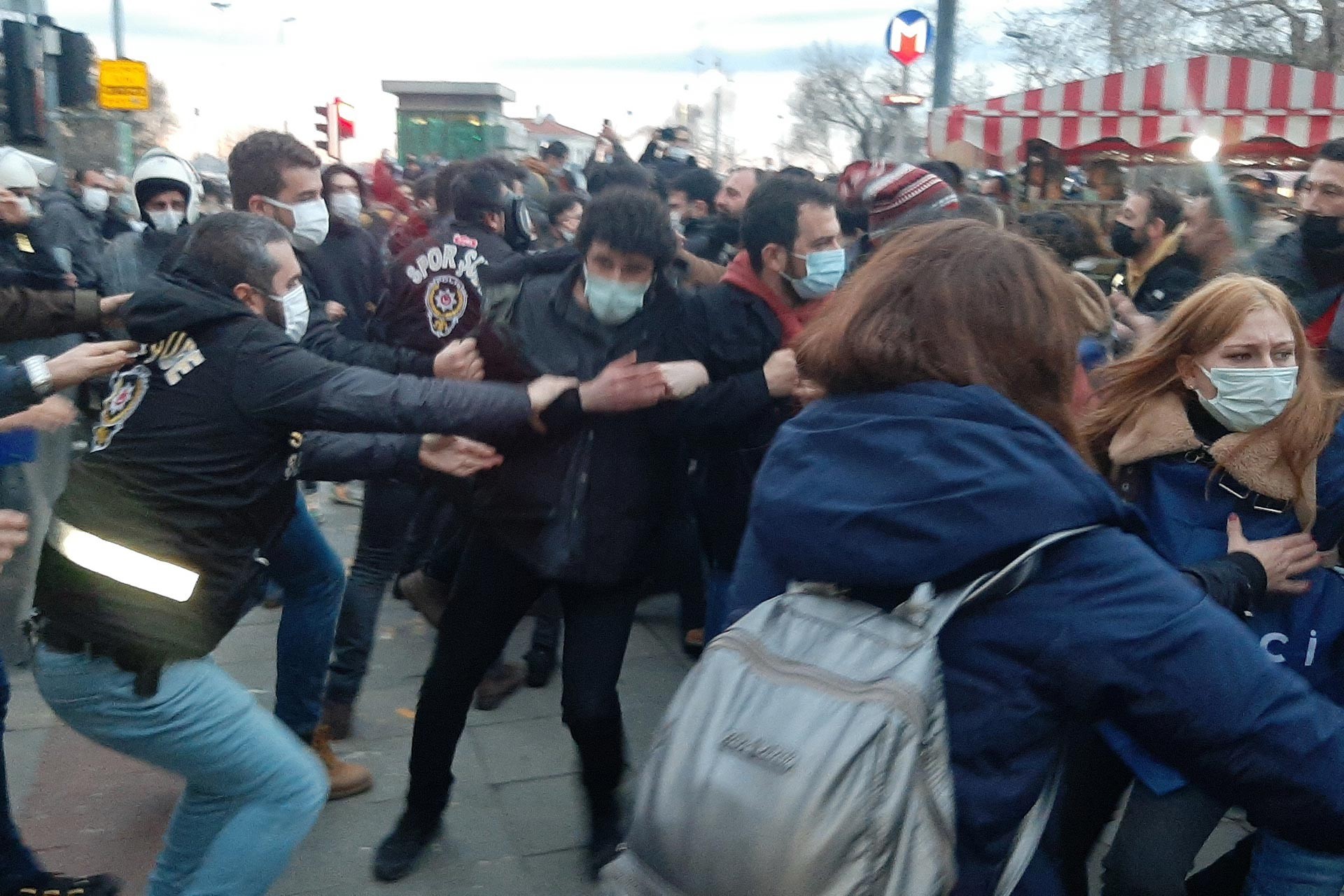 Öğrencileri koluna yapışan polisler (solda) 