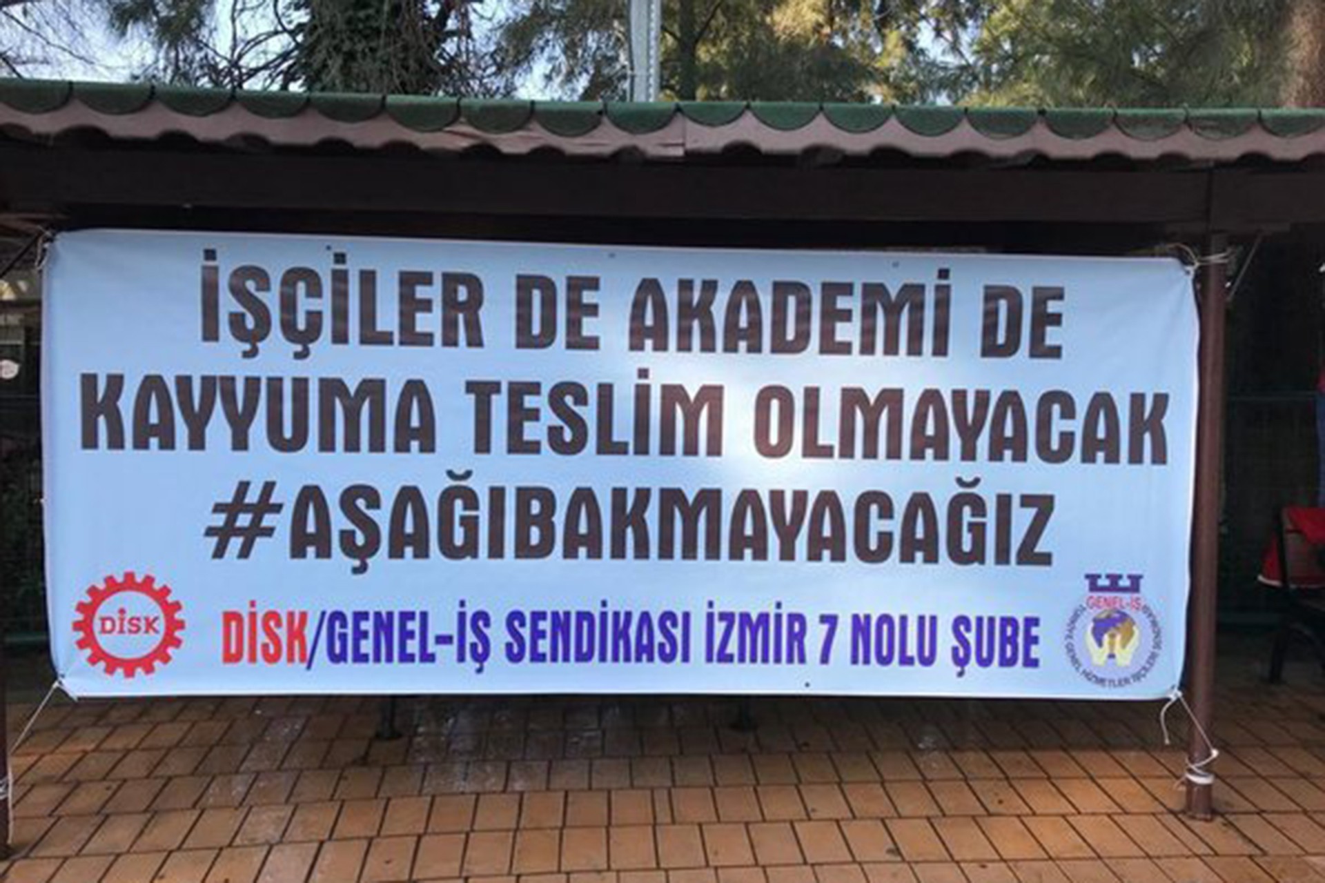 İşçiler de akademi de kayyuma teslim olmayacak #AşağıBakmayacağız yazılı pankart