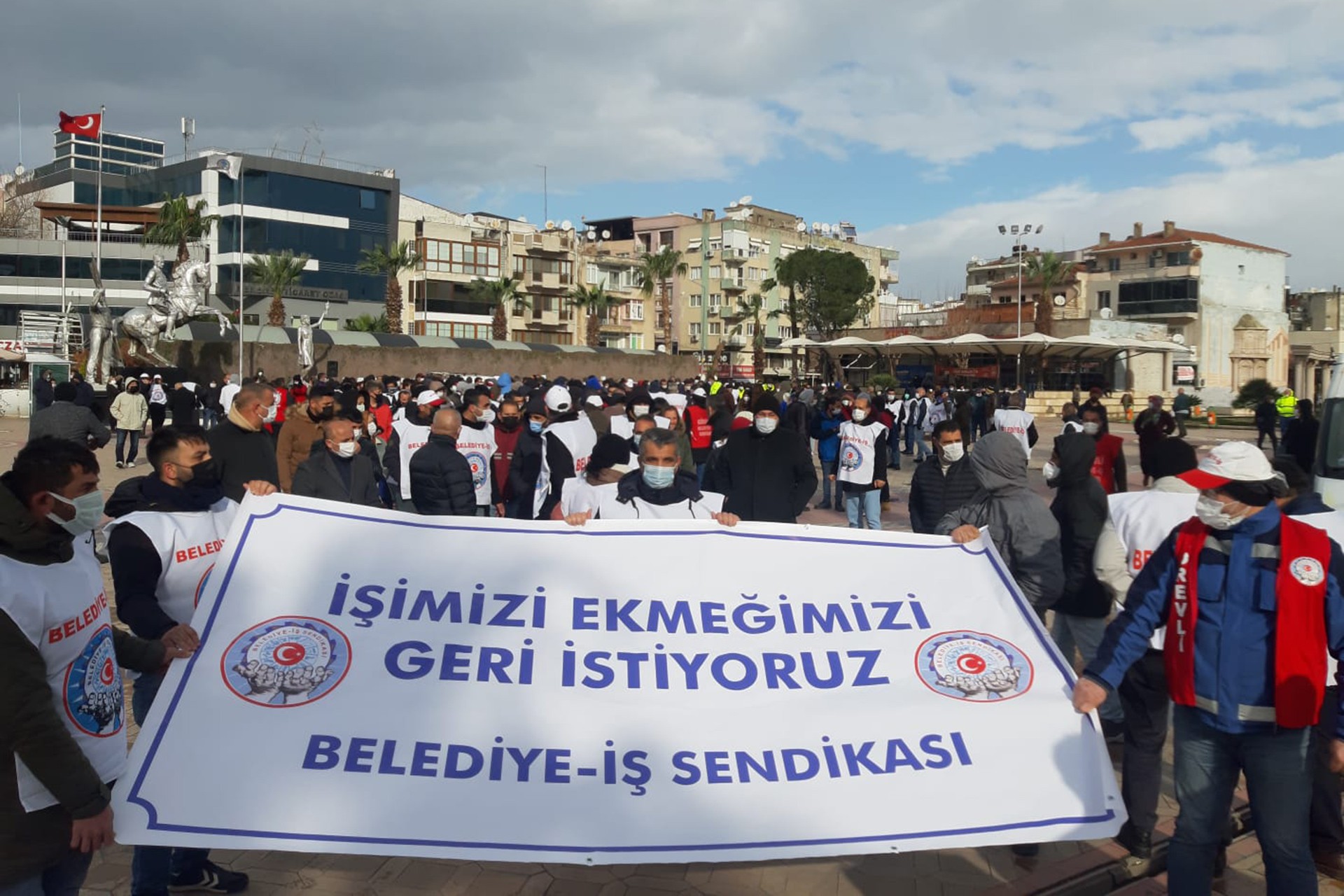 İşimizi ekmeğimizi geri istiyoruz pankartı ve arkasında yürüyüş yapan Menemen Belediyesi işçileri