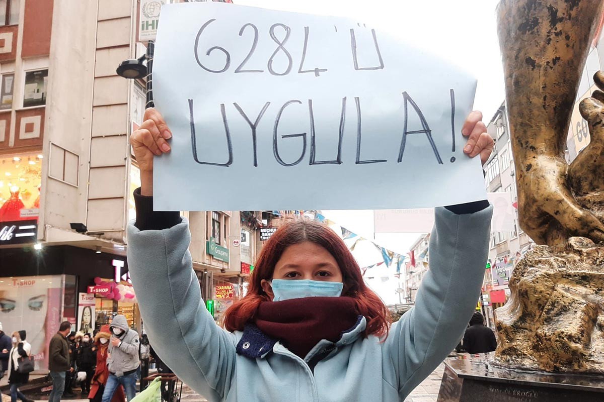 6284 ile ilgili pankart tutan kadın