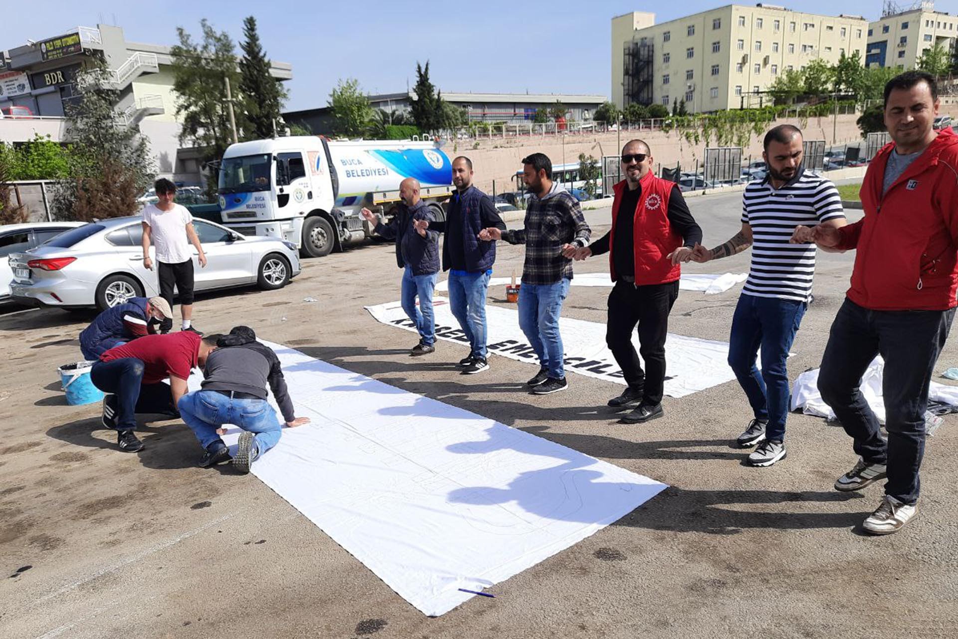 İşçiler halaylar eşliğinde 1 Mayıs pankartlarını hazırlıyor