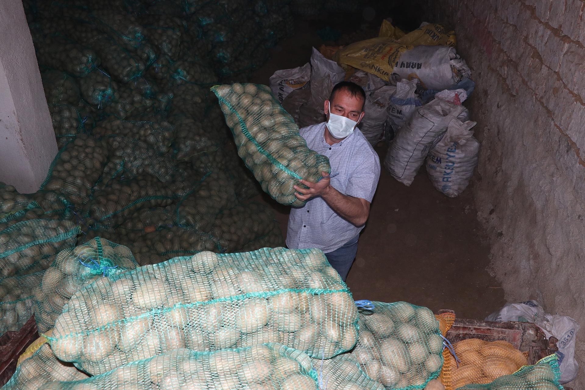 Patates çuvalını taşıyan erkek