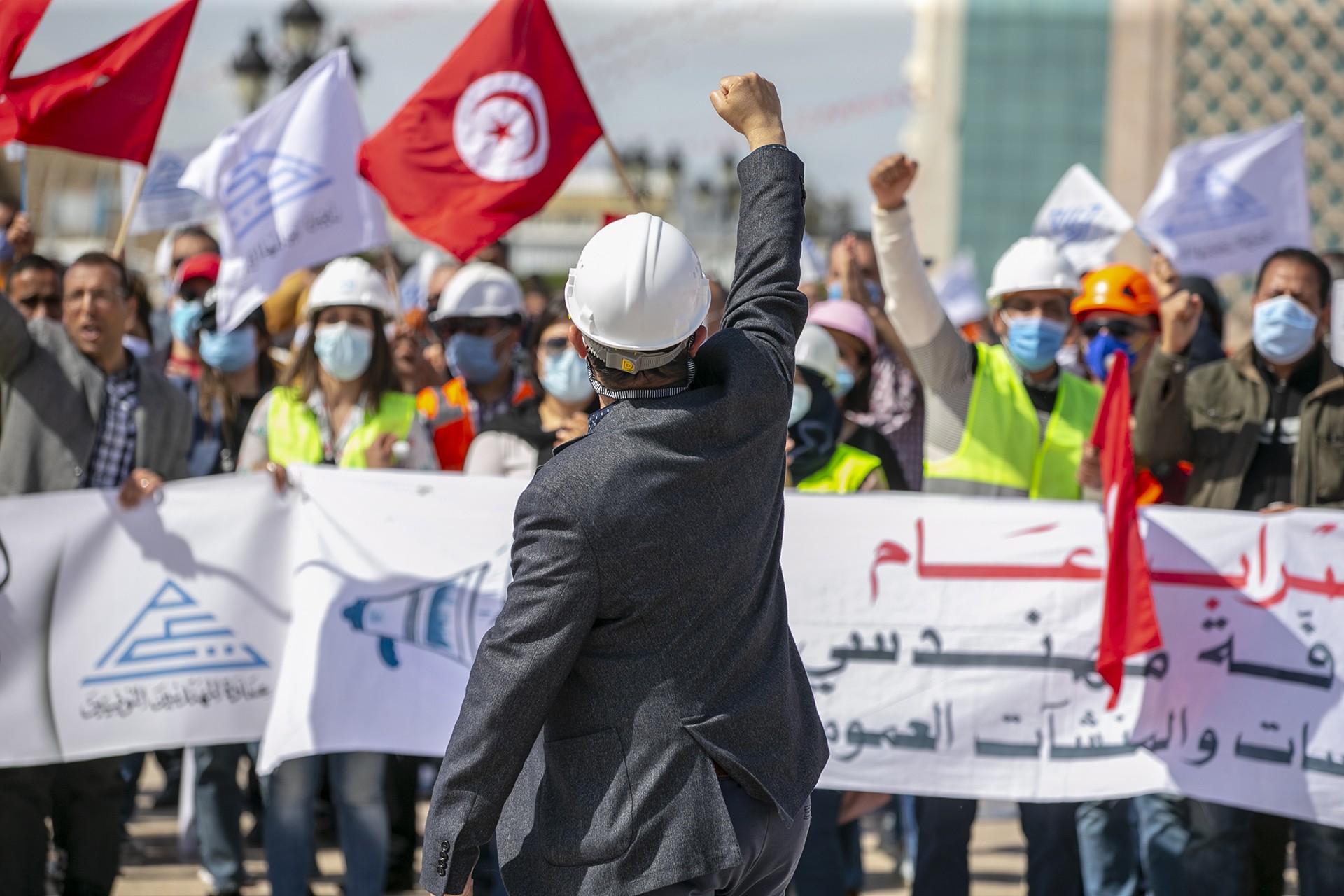 Tunus'ta eylem, sağ yumruğunu hava kaldıran bir baretli