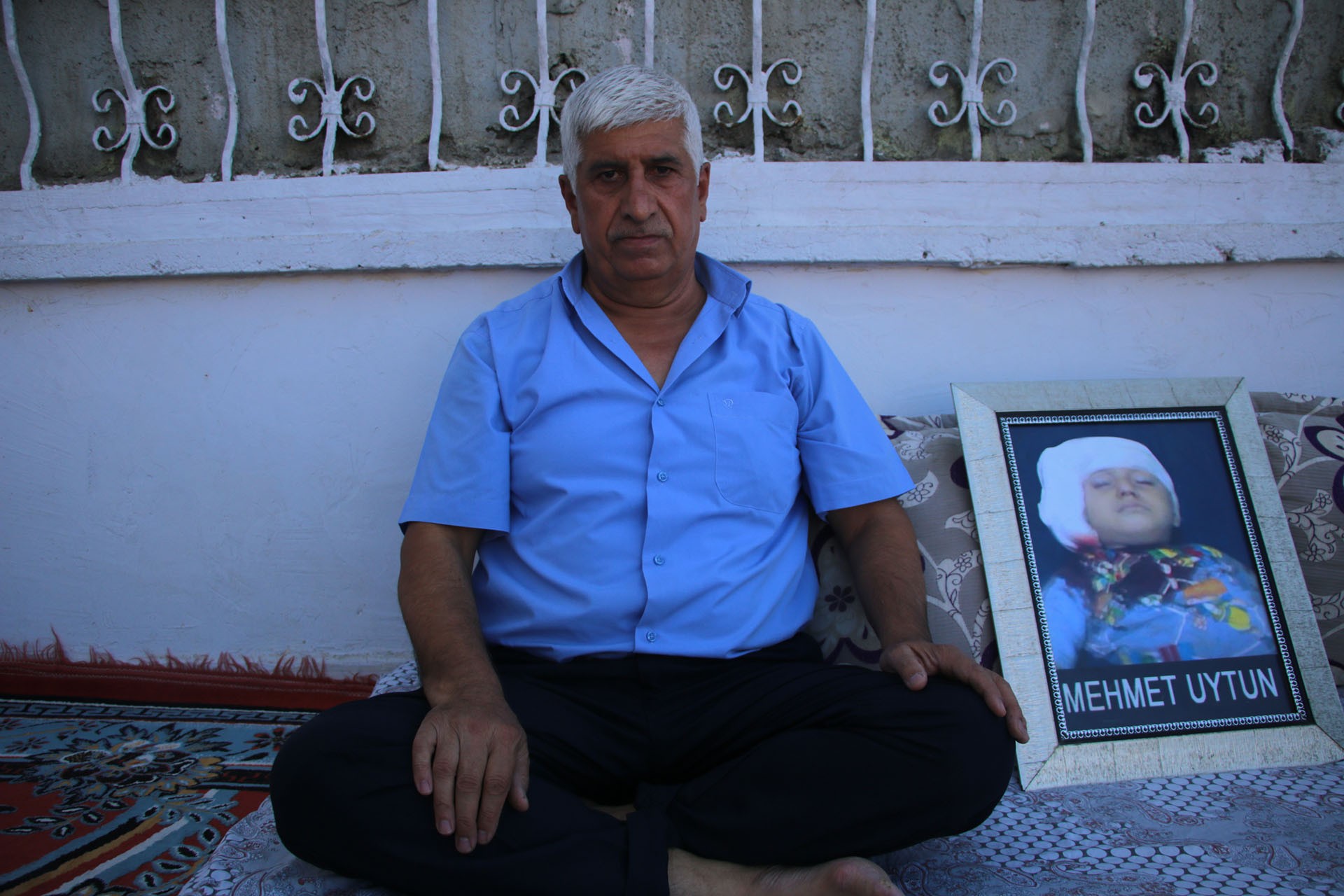 Mehmet Uytunun fotoğrafının yanında oturan baba Turan Uytun