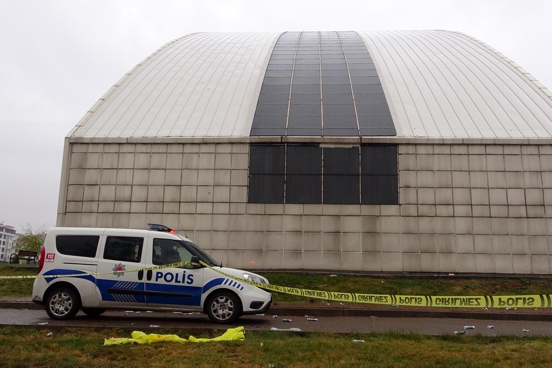 Mülteci işçinin düştüğü binanın görüntüsü önünde polis aracı ile yağmurlu bir görüntü