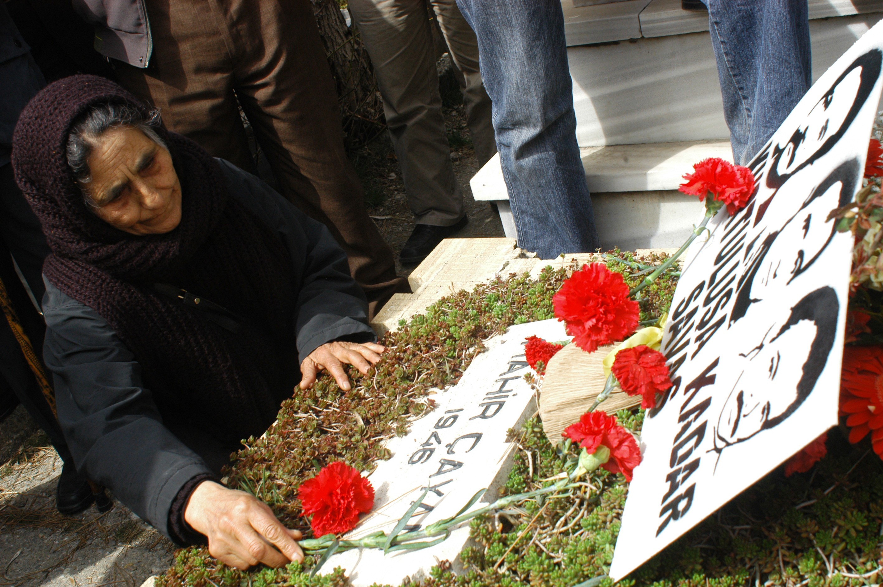 Mahir Çayan'ın anma etkinliğinde mezara karanfil bırakan bir kadın.