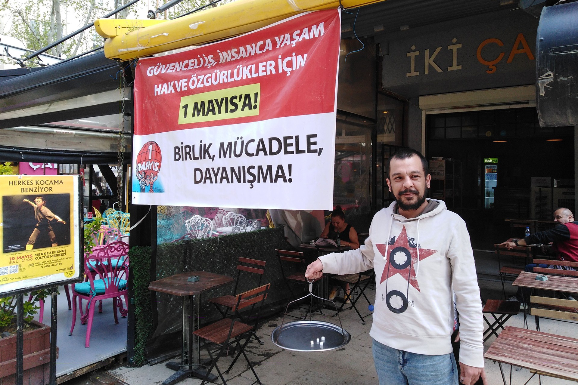 1 Mayıs pankartı önünden bir esnaf