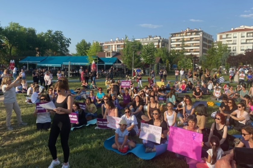 yoga yapan yüzlerce kadın ellerini havaya kaldırmış