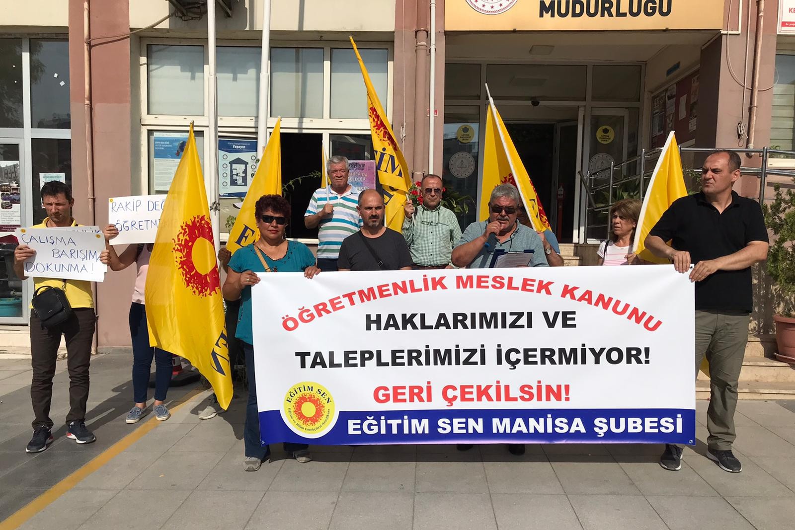 eğitim sen üyeleri ellerinde bayrak ve pankartla açıklama yaparken