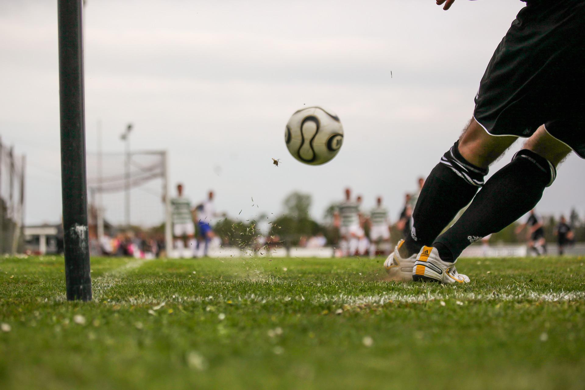 Sadece ayakları görünen bir futbolcu topa vuryor. 