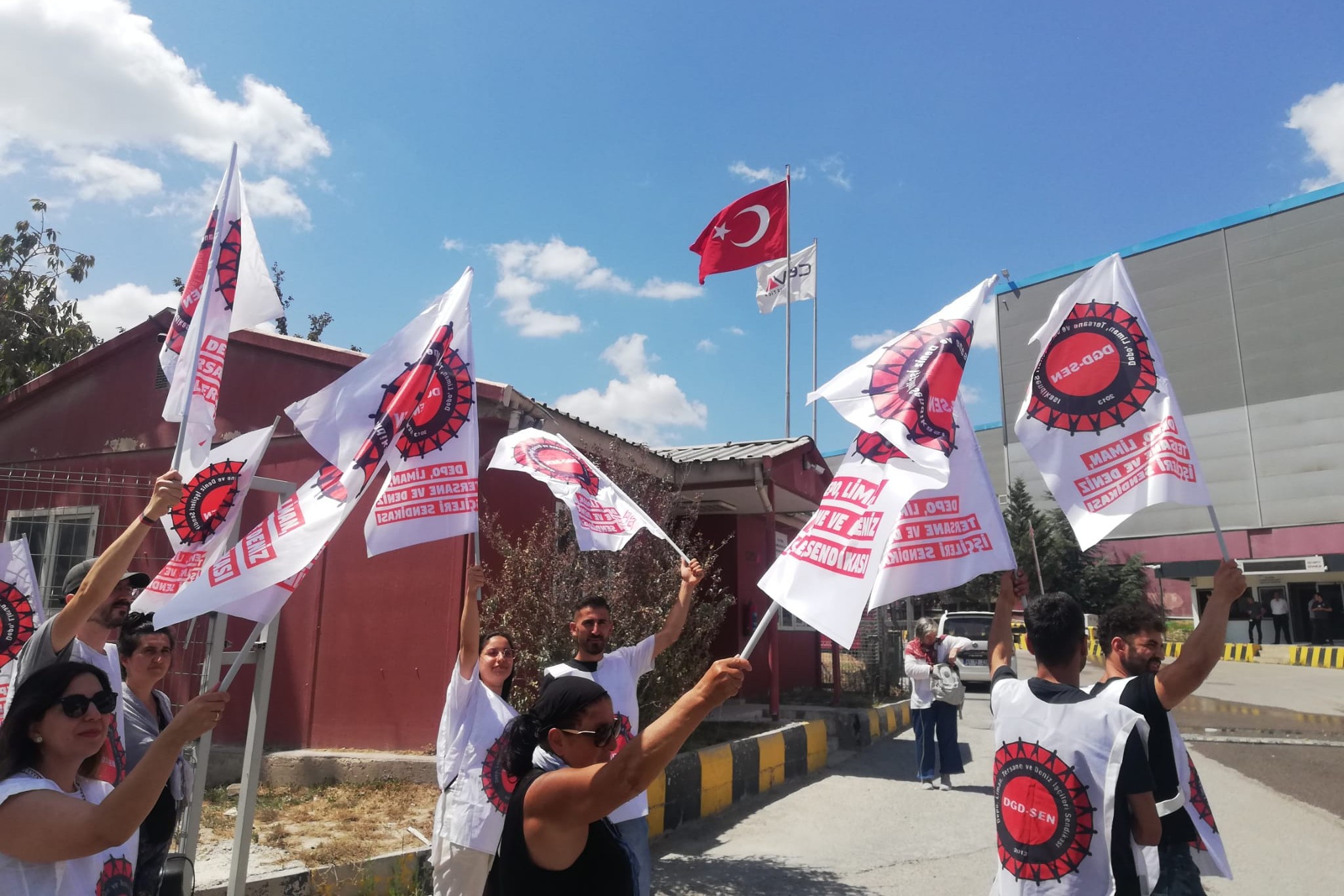 elinde bayrak tutan işçiler