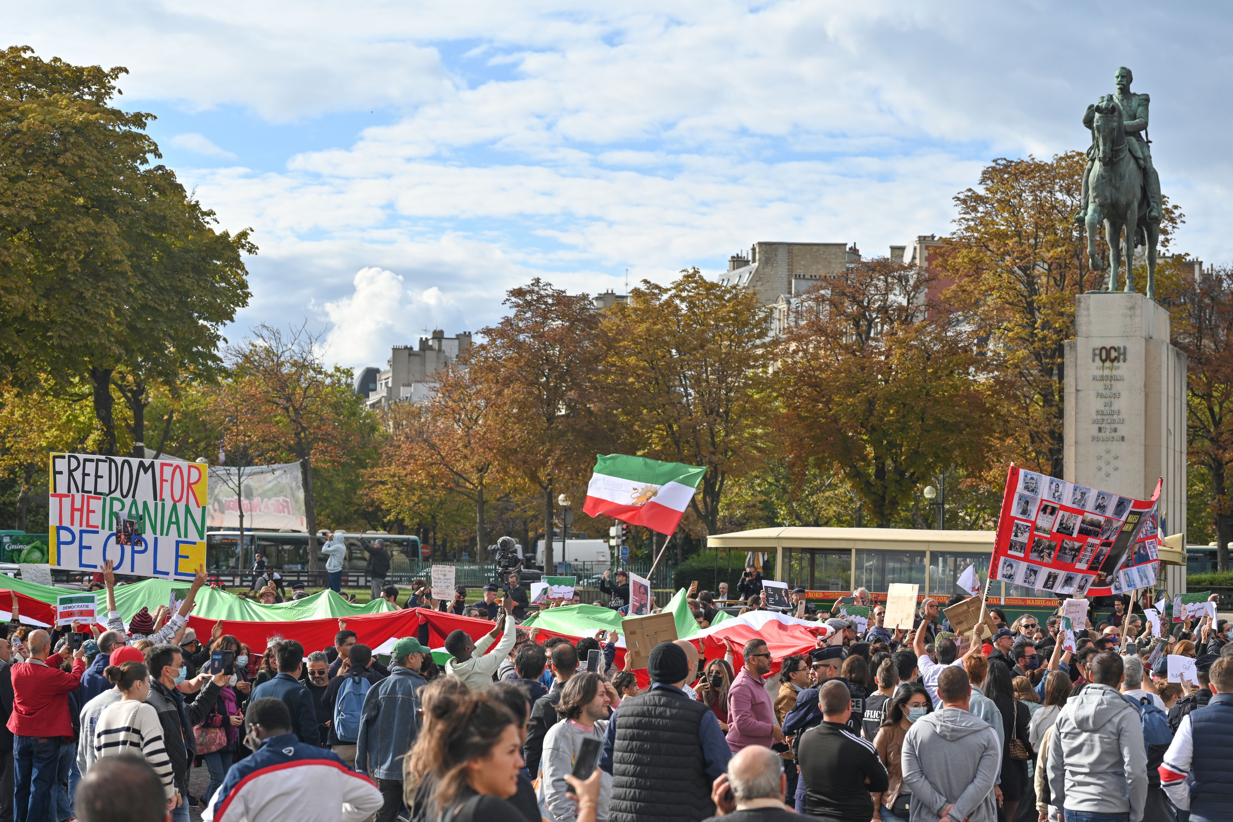 ellerinde iran bayrakları ve dövizler olan insanlar