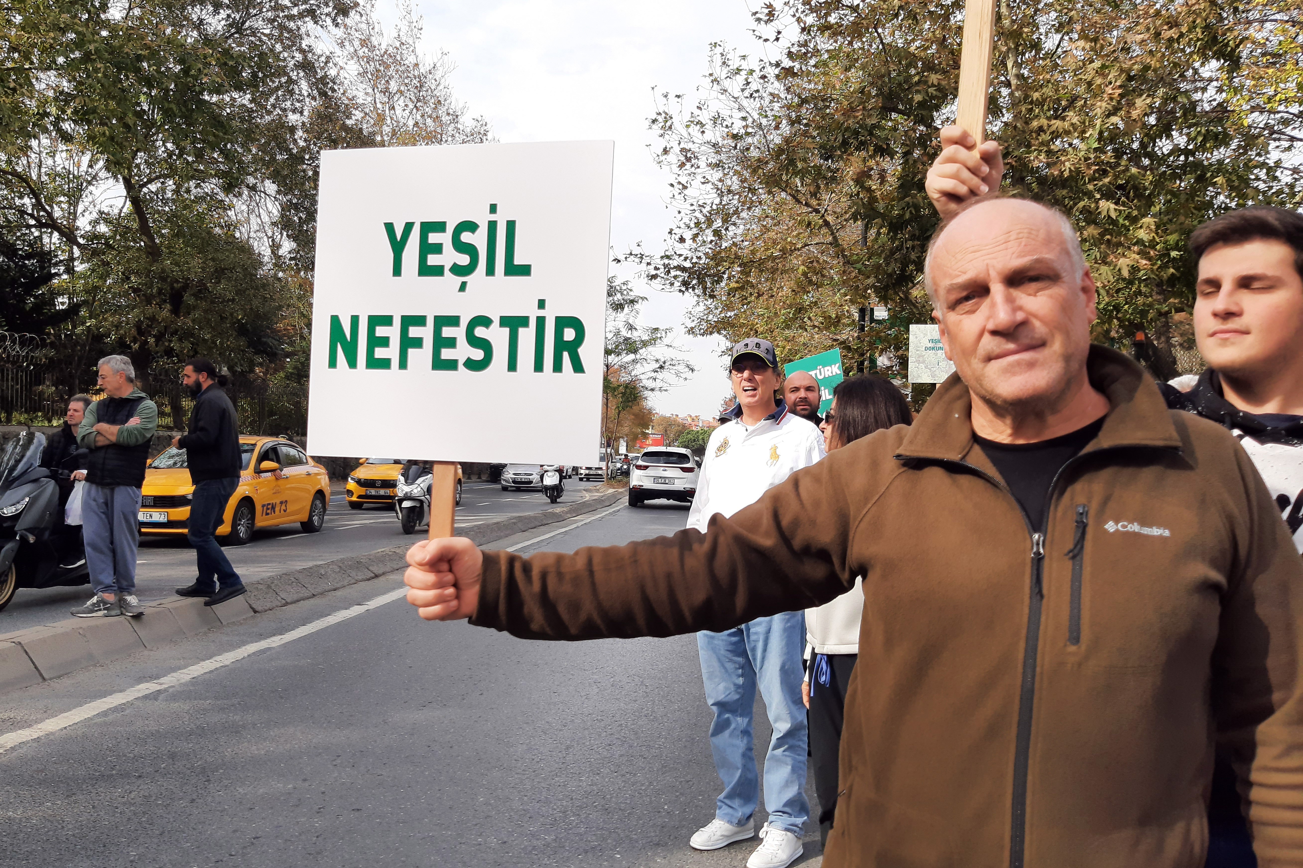 Yeşil nefestir yazılı döviz taşıyan kişi.