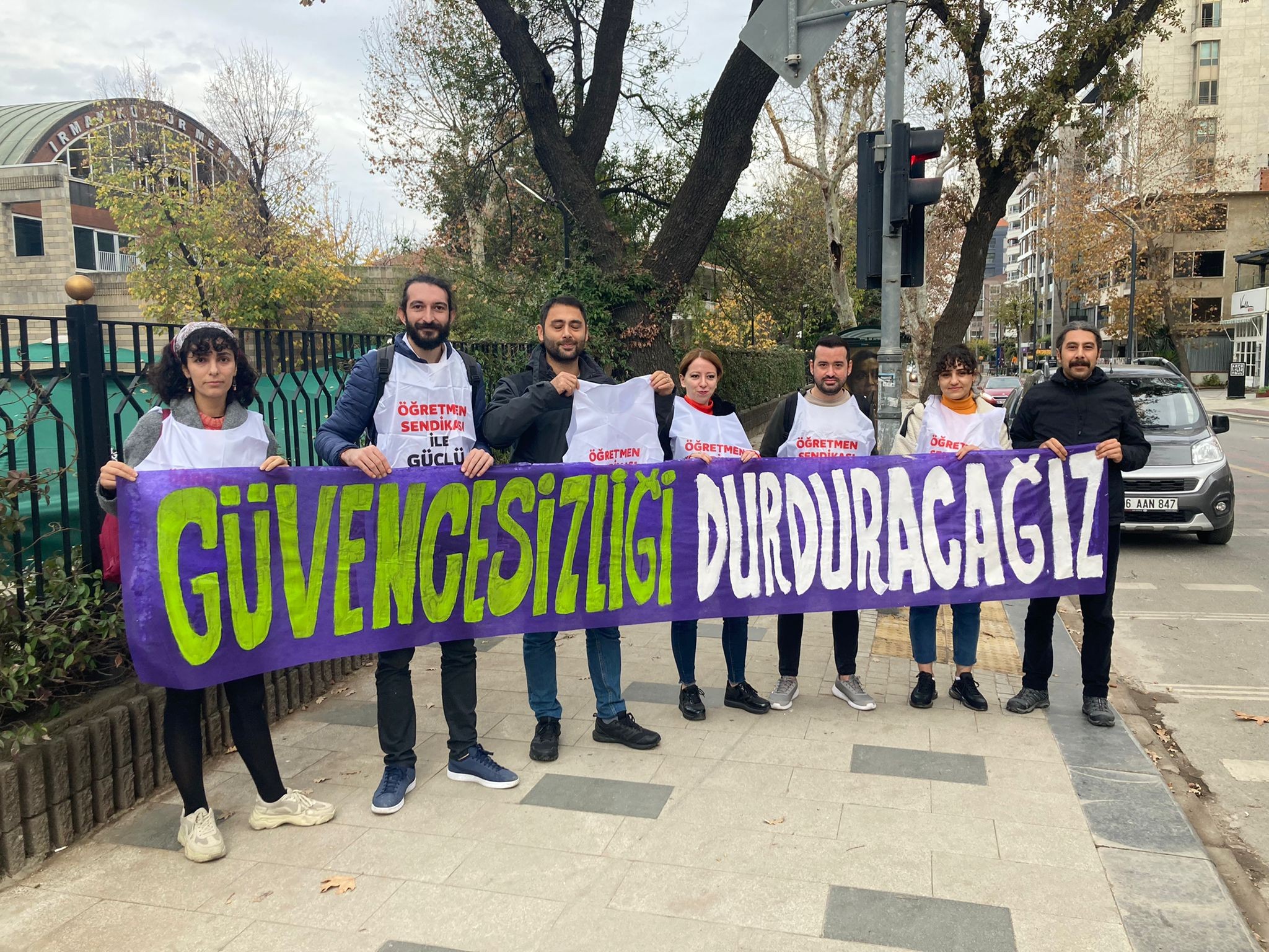 Öğretmenler ellerinde 'güvencesizliği durduracağız' yazılı pankart ile poz veriyor