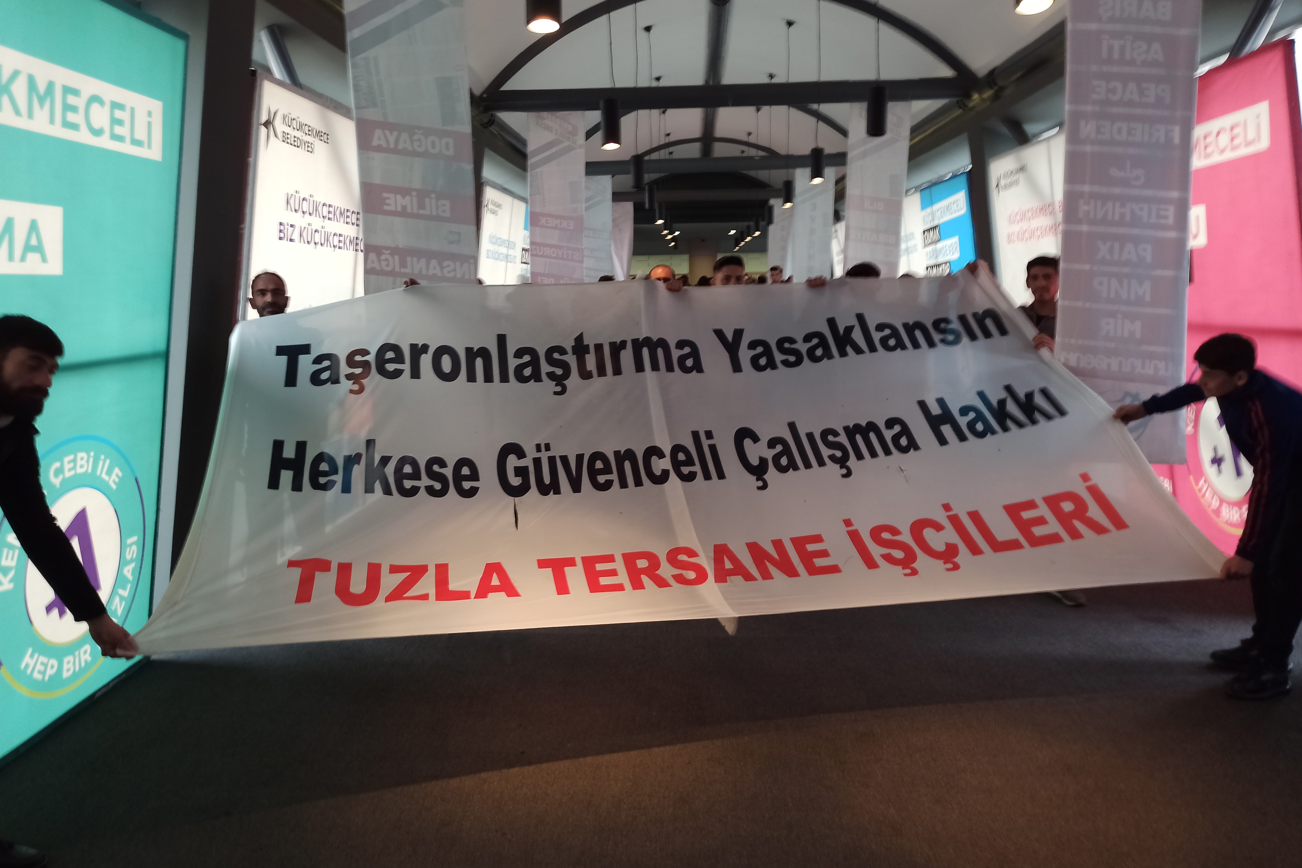 Tuzla tersane işçileri pankartları ile salonda.