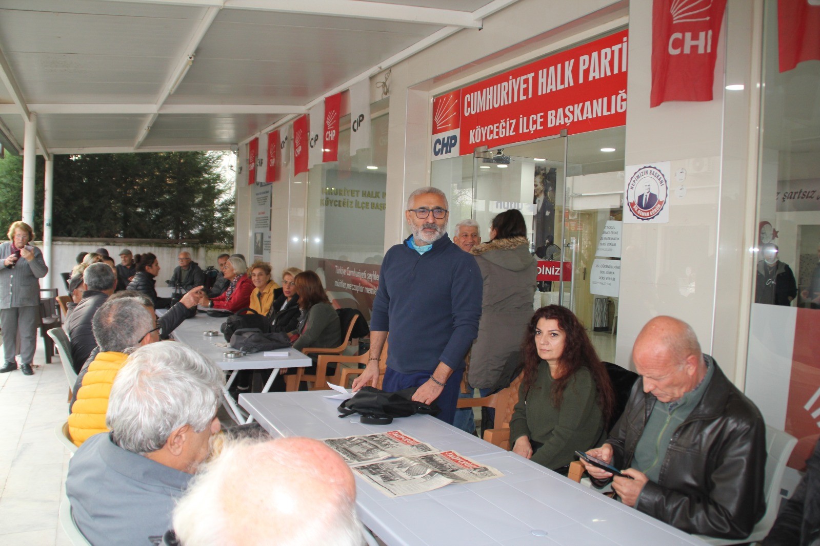 CHP ilçe binası girişinde oturan insanlar