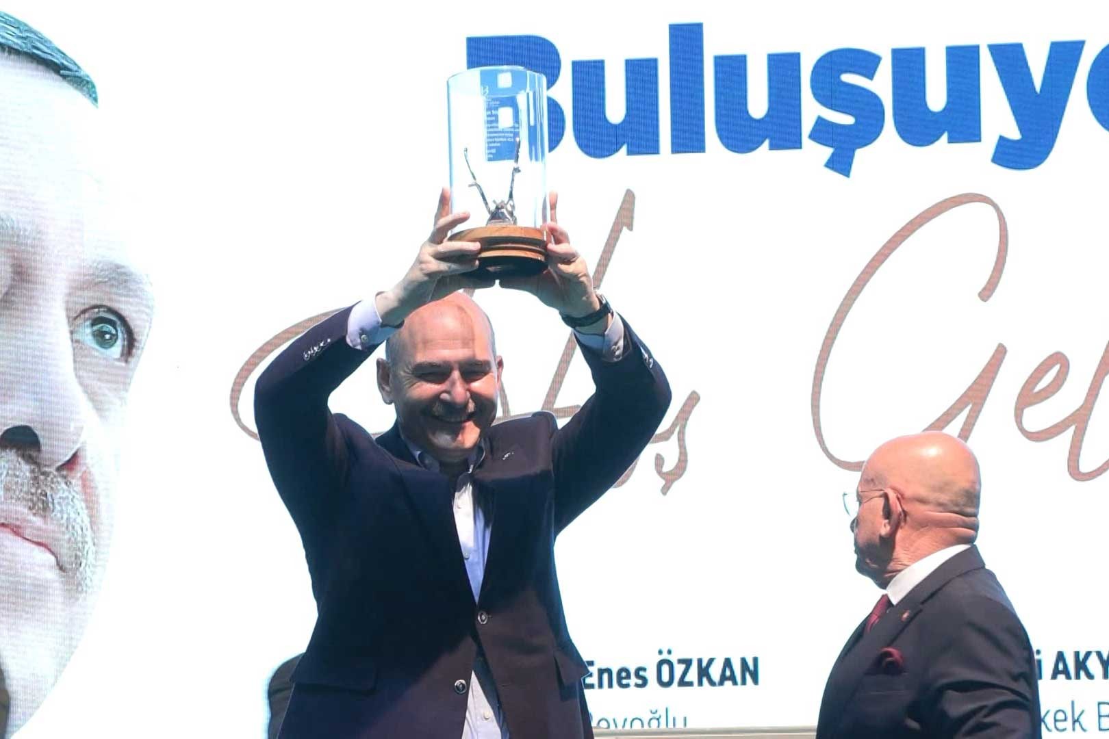 Süleyman Soylu, berberlerin hediye ettiği saç kesme makasını kaldırırken