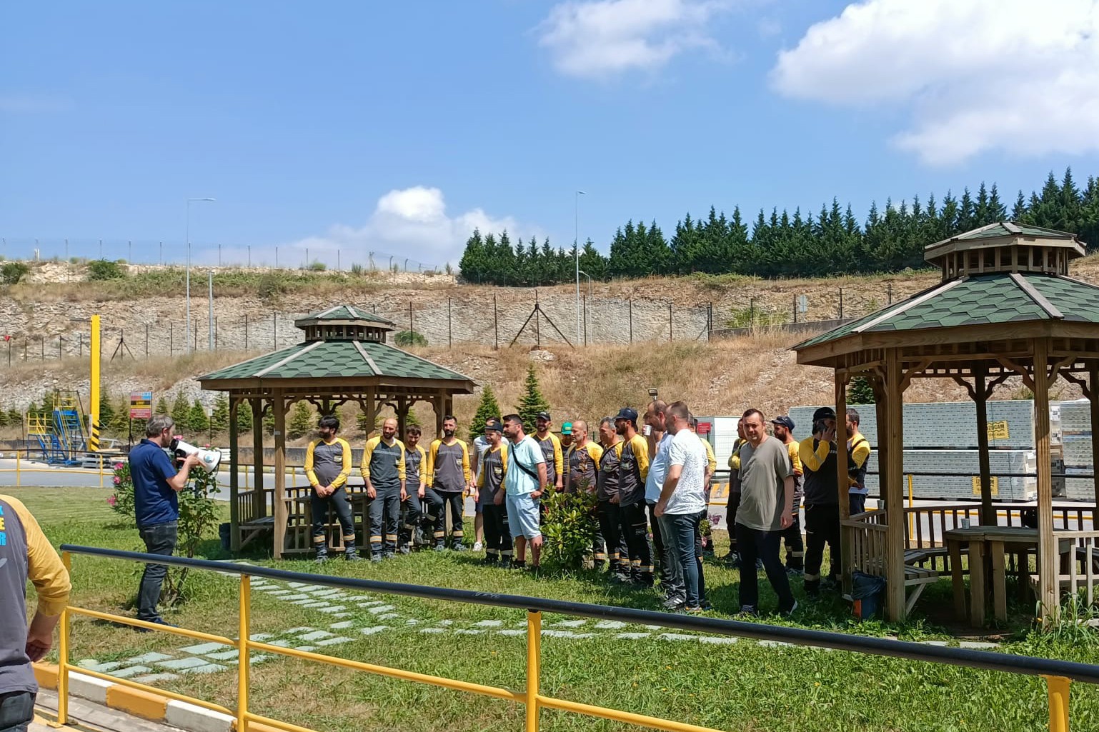 Fabrika bahçesinde bir arada duran işçiler