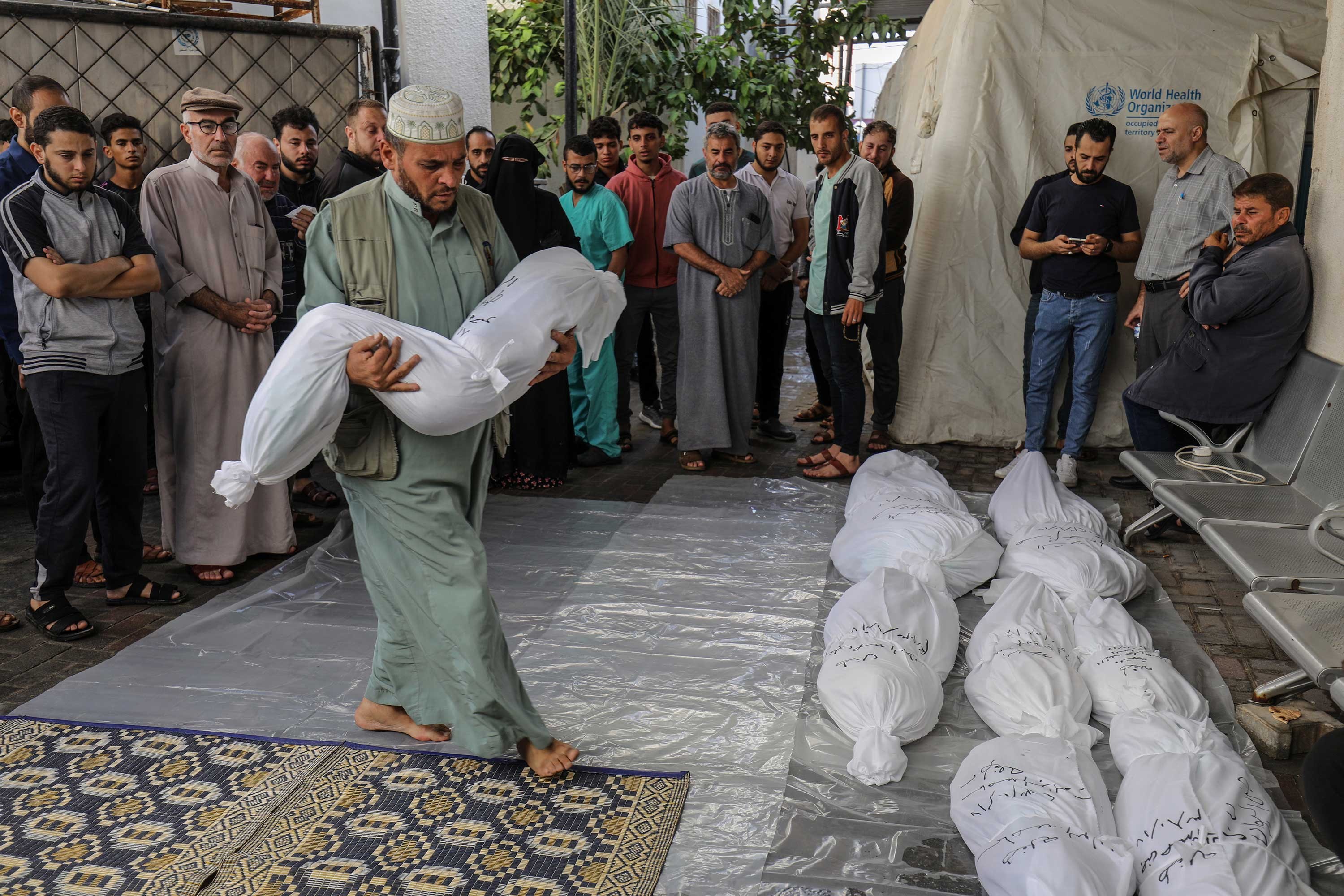 İsrail'in saldırılarında hayatını kaybedenlerin naaşları, yakınları tarafından toprağa verilmek üzere Gazze'nin Refah kentindeki En-Neccar Hastanesi morgundan alındı