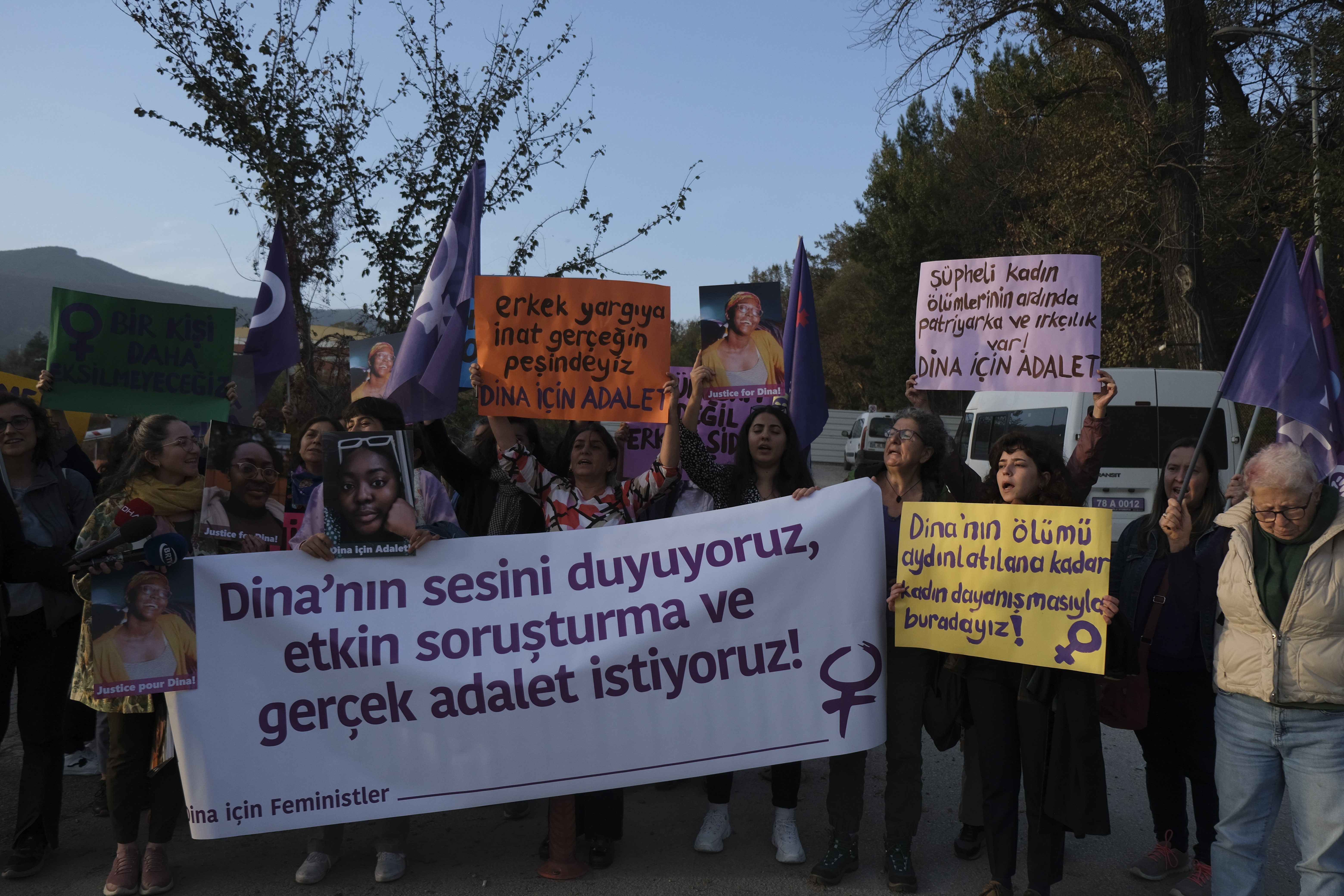 Ellerinde Dina için sloganların yazılı olduğu pankartları tutan kadınlar