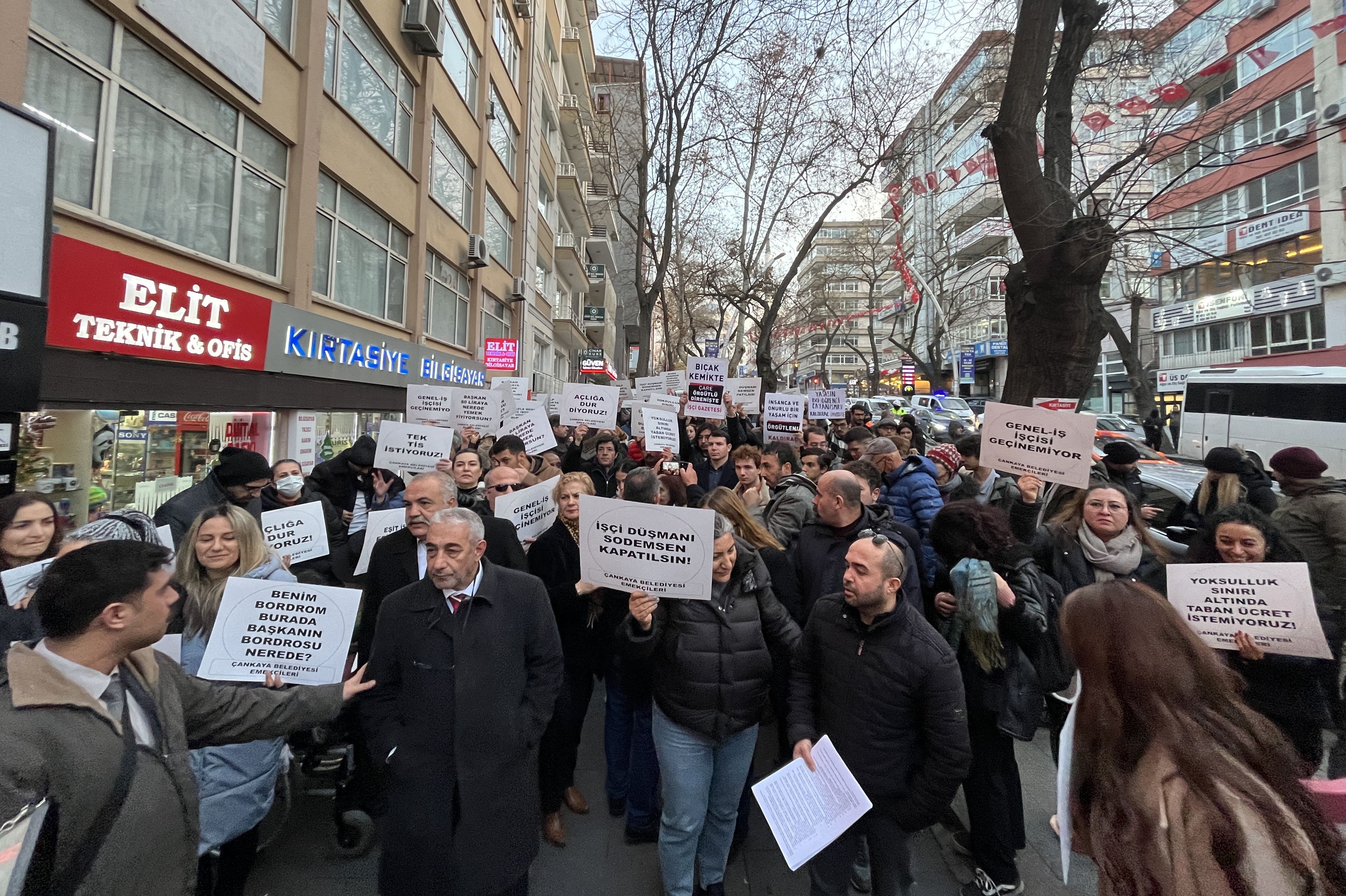 ellerinde taleplerinin yazdığı kartonları taşıyan işçiler