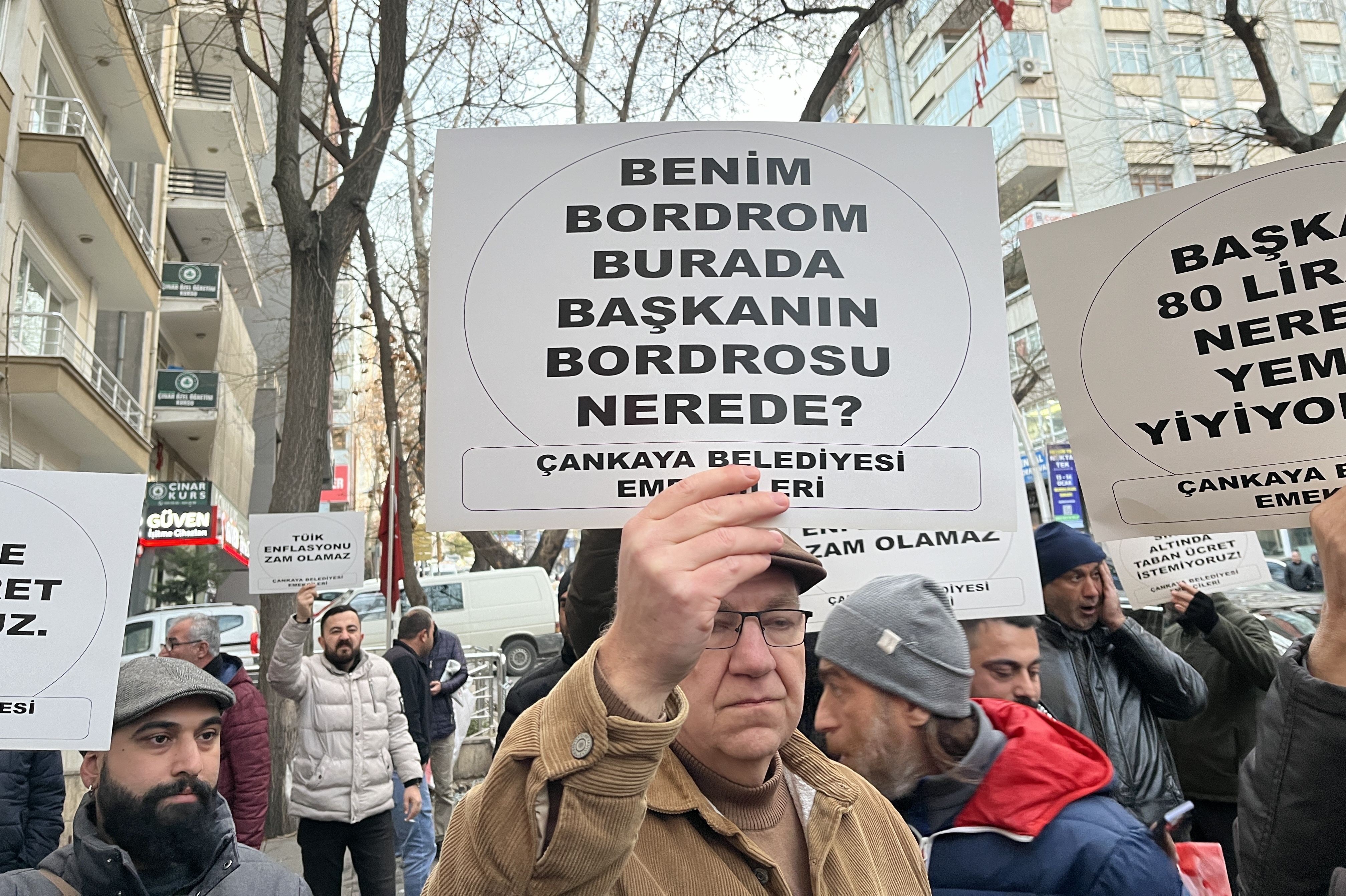 ellerinde taleplerinin yazdığı kartonları taşıyan işçiler