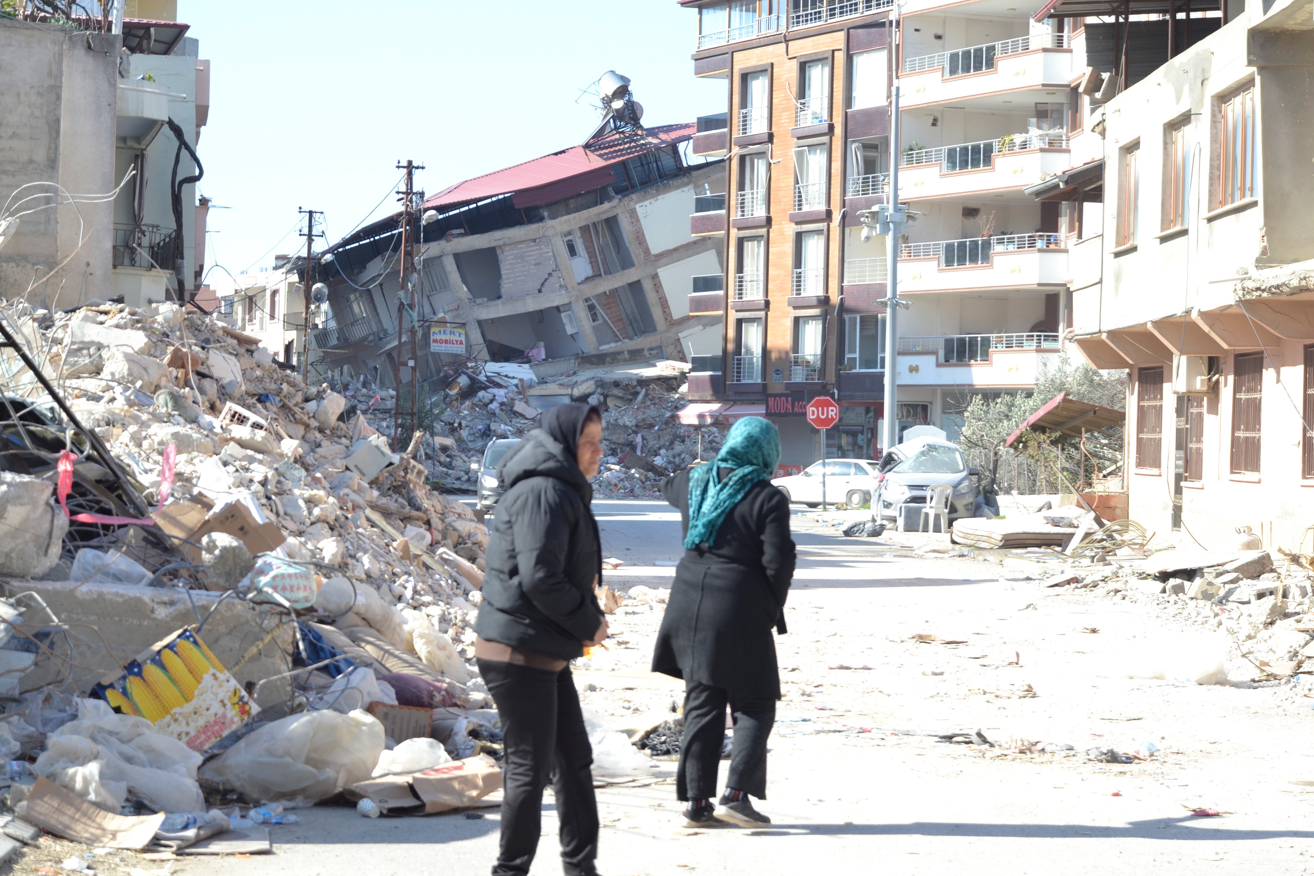 Deprem sonrası insanlar ve enkaz görüntüsü.