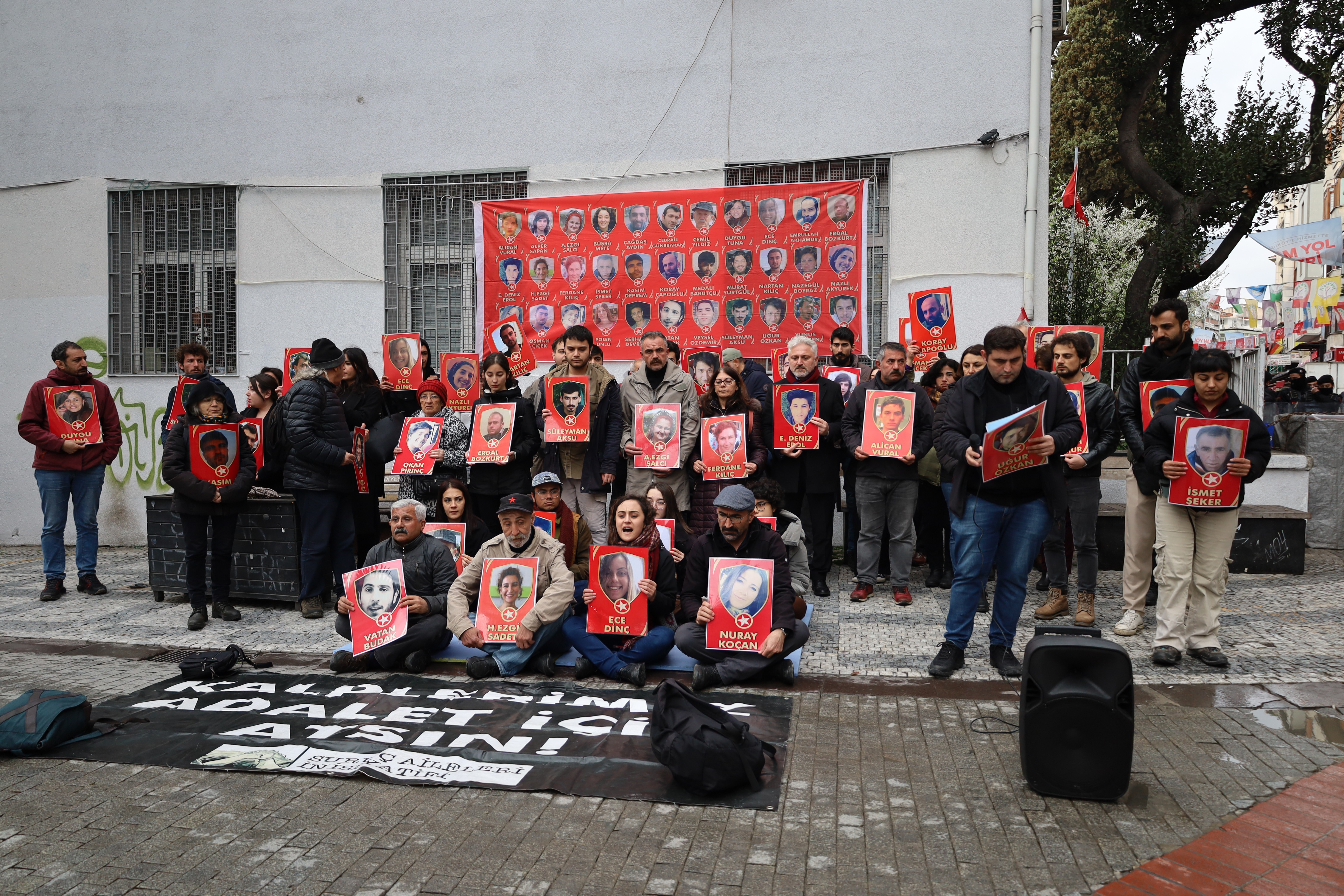 yakınlarının fotoğraflarını taşıyan insanlar